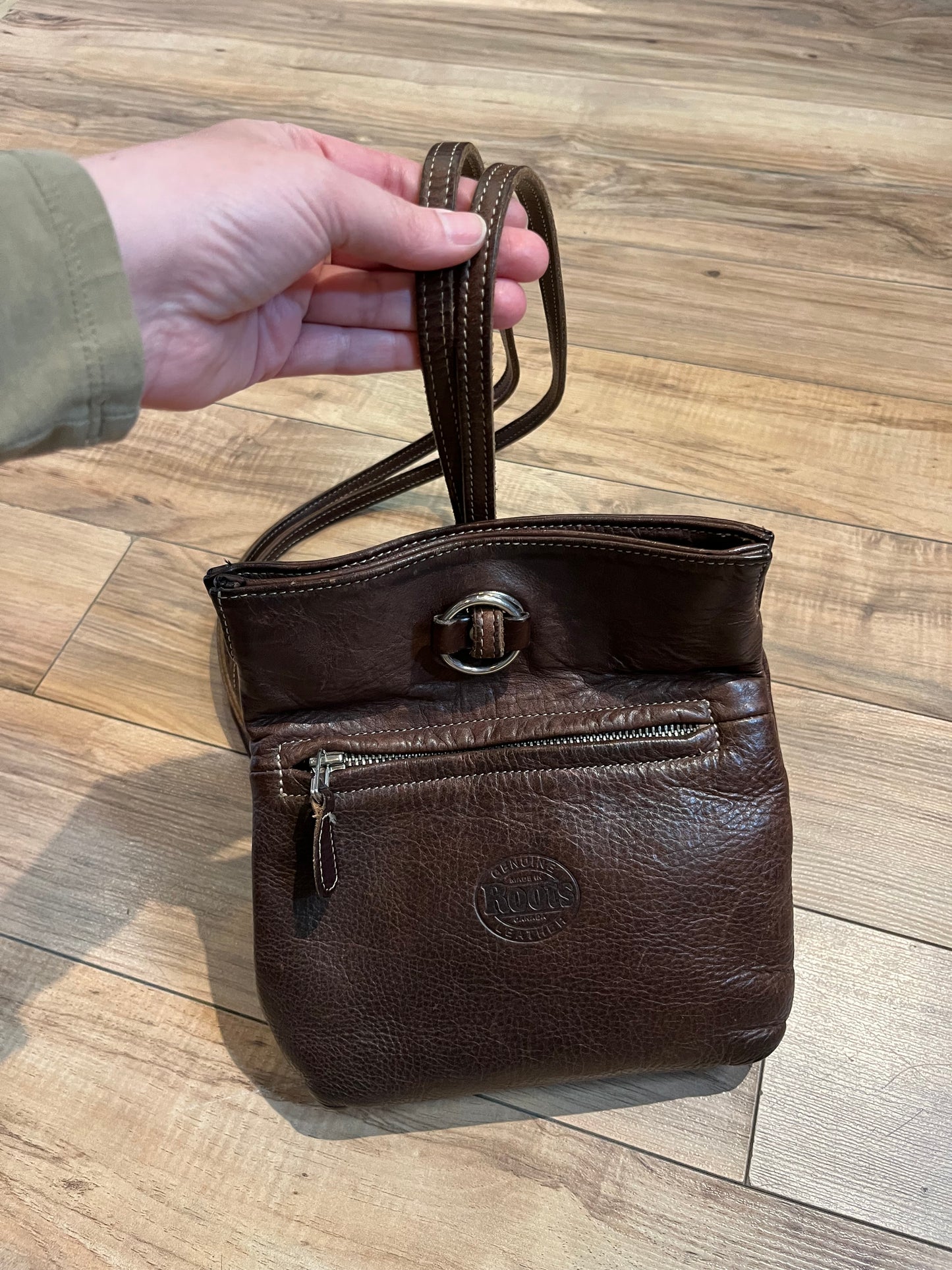 Vintage Roots brown leather crossbody/ knapsack, with two shoulder straps which can we worn as a knapsack or unclipped and worn as a cross body bag, one outer zip pocket and one main inner compartment.