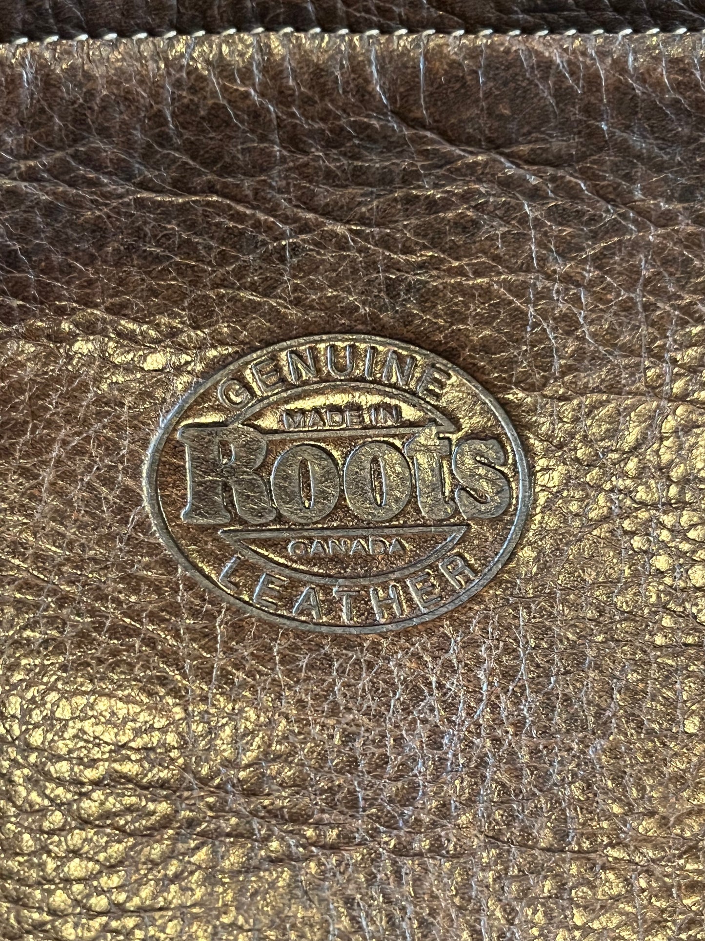 Vintage Roots brown leather crossbody/ knapsack, with two shoulder straps which can we worn as a knapsack or unclipped and worn as a cross body bag, one outer zip pocket and one main inner compartment.
