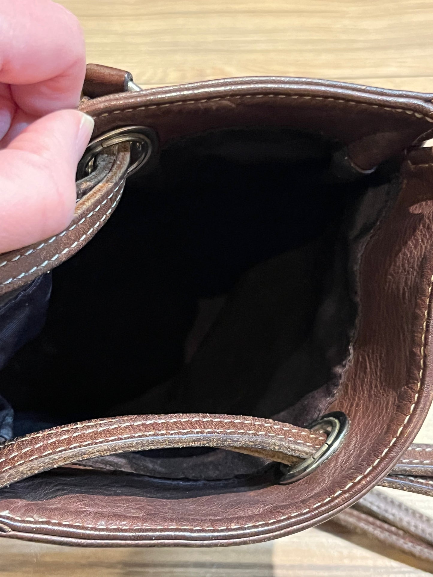 Vintage Roots brown leather crossbody/ knapsack, with two shoulder straps which can we worn as a knapsack or unclipped and worn as a cross body bag, one outer zip pocket and one main inner compartment.