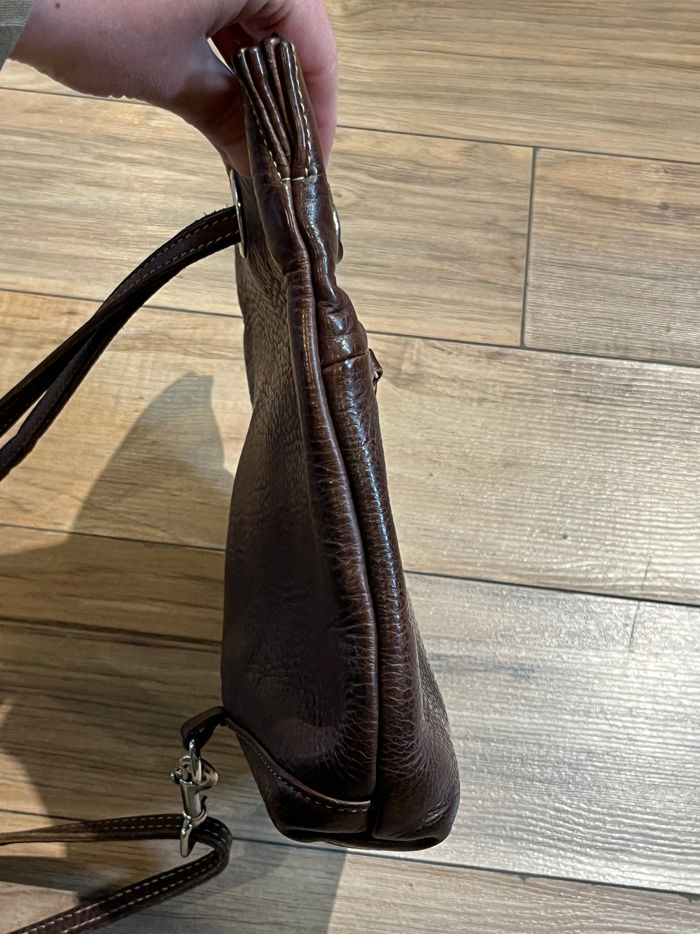 Vintage Roots brown leather crossbody/ knapsack, with two shoulder straps which can we worn as a knapsack or unclipped and worn as a cross body bag, one outer zip pocket and one main inner compartment.