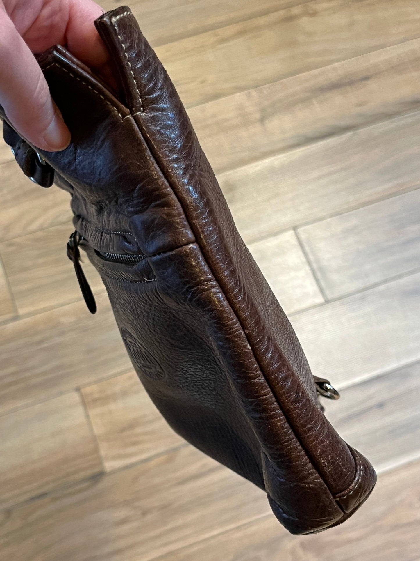 Vintage Roots brown leather crossbody/ knapsack, with two shoulder straps which can we worn as a knapsack or unclipped and worn as a cross body bag, one outer zip pocket and one main inner compartment.