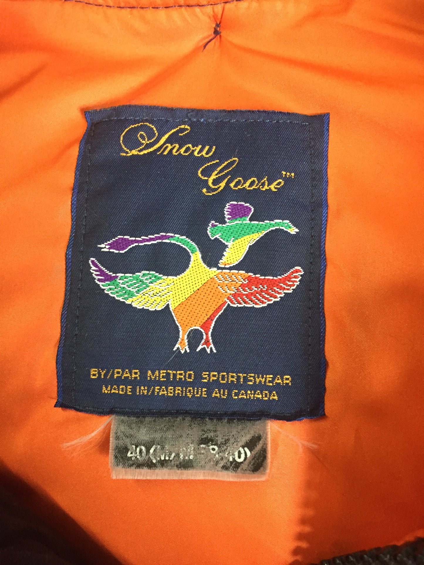 Kingspier Vintage - Rare Snow Goose parka from the 1970’s/1980’s (former name of Canada Goose) in navy with leather details and fur trimmed hood, slash pockets, flap pockets, zipper and button closures, “Snow Goose” patch on the front pocket, orange lining. Made in Canada. Size 40M.