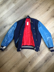Kingspier Vintage - Blue wool varsity jacket with blue leather arms, snap closures, slash pockets and red quilted lining. Size 44.
