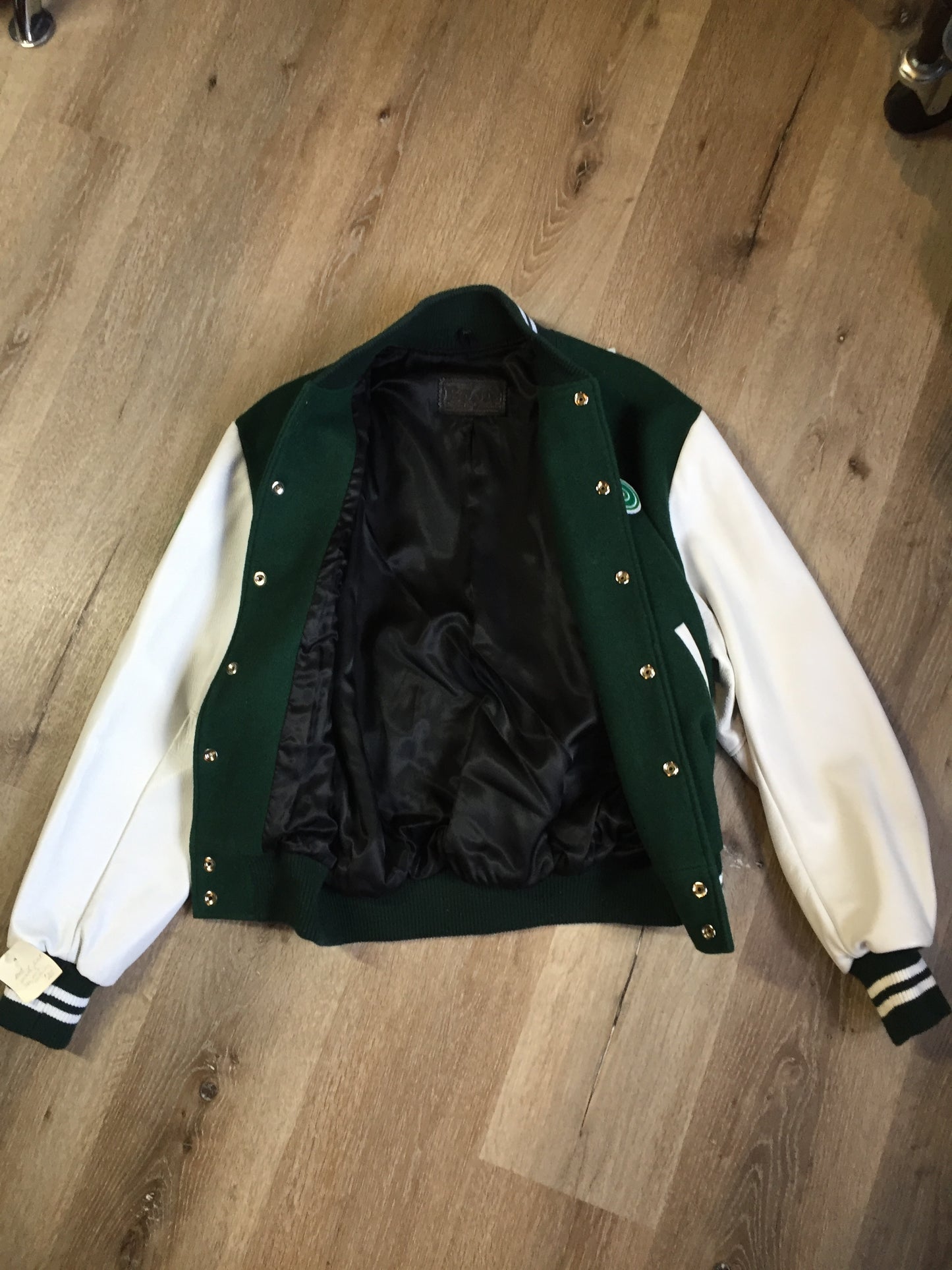 Kingspier Vintage - Roots “Sobey’s Centenary Anniversary” ’07 varsity jacket in green and white with snap closures, slash pockets, knit trim, embroidered “100” emblem on the chest and “07” on the arm.