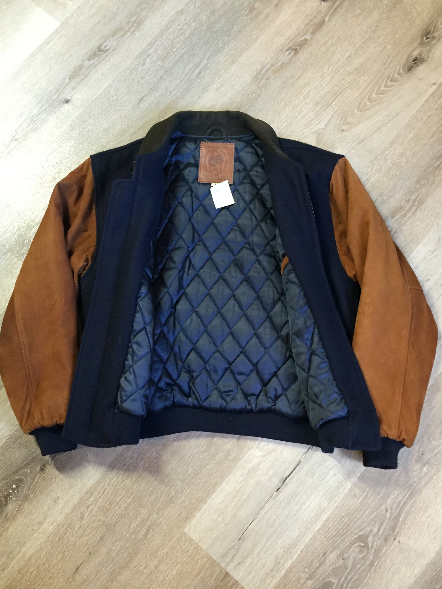 Kingspier Vintage - AES 1997 brown and blue leather and wool varsity jacket with zipper, slash pockets , quilted lining, inside pocket, embroidered emblem on the chest and “AES” printed across the back.