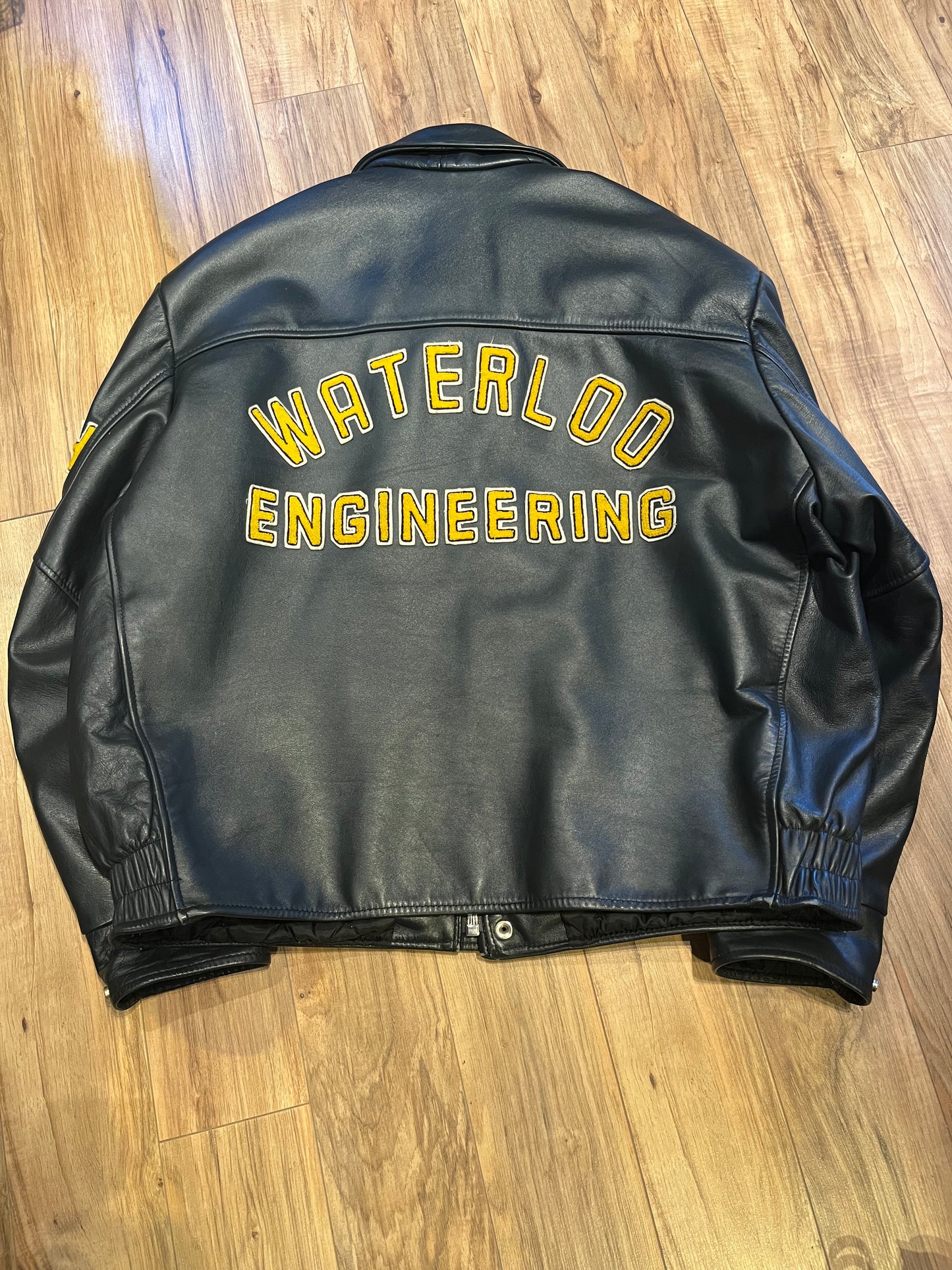 Vintage 70’s Waterloo Engineering Letterman’s leather varsity jacket by Export Leather Garments LTD.
Jacket features embroidered details on the chest, arms and back, two front pockets, zipper and snap closures and a quilted lining.
Made in Canada.
Size 52.