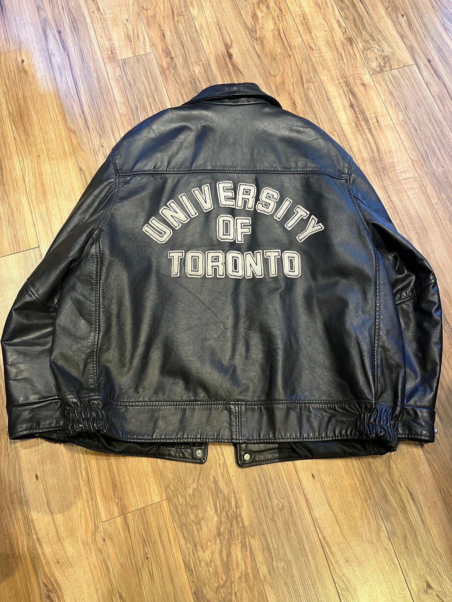 Vintage University of Toronto 1998 English Department Leather Varsity Jacket.
Jacket features embroidered details on the chest, arms and back, two front pockets, zipper and snap closures and a zip out quilted lining.
Size 46.