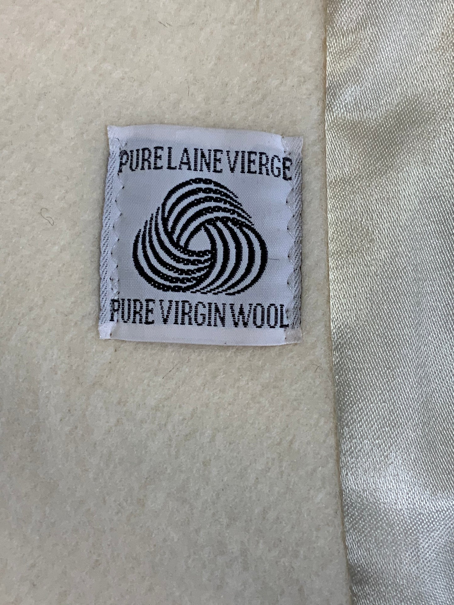 Kingspier Vintage - Genuine Hudson Bay Company 100% virgin wool coat in white with black leather trim, front pockets, flat black buttons and a unique mandarin collar with cape style detail around shoulders. Contains a Hudson’s Bay seal of quality tag. Made in Canada.