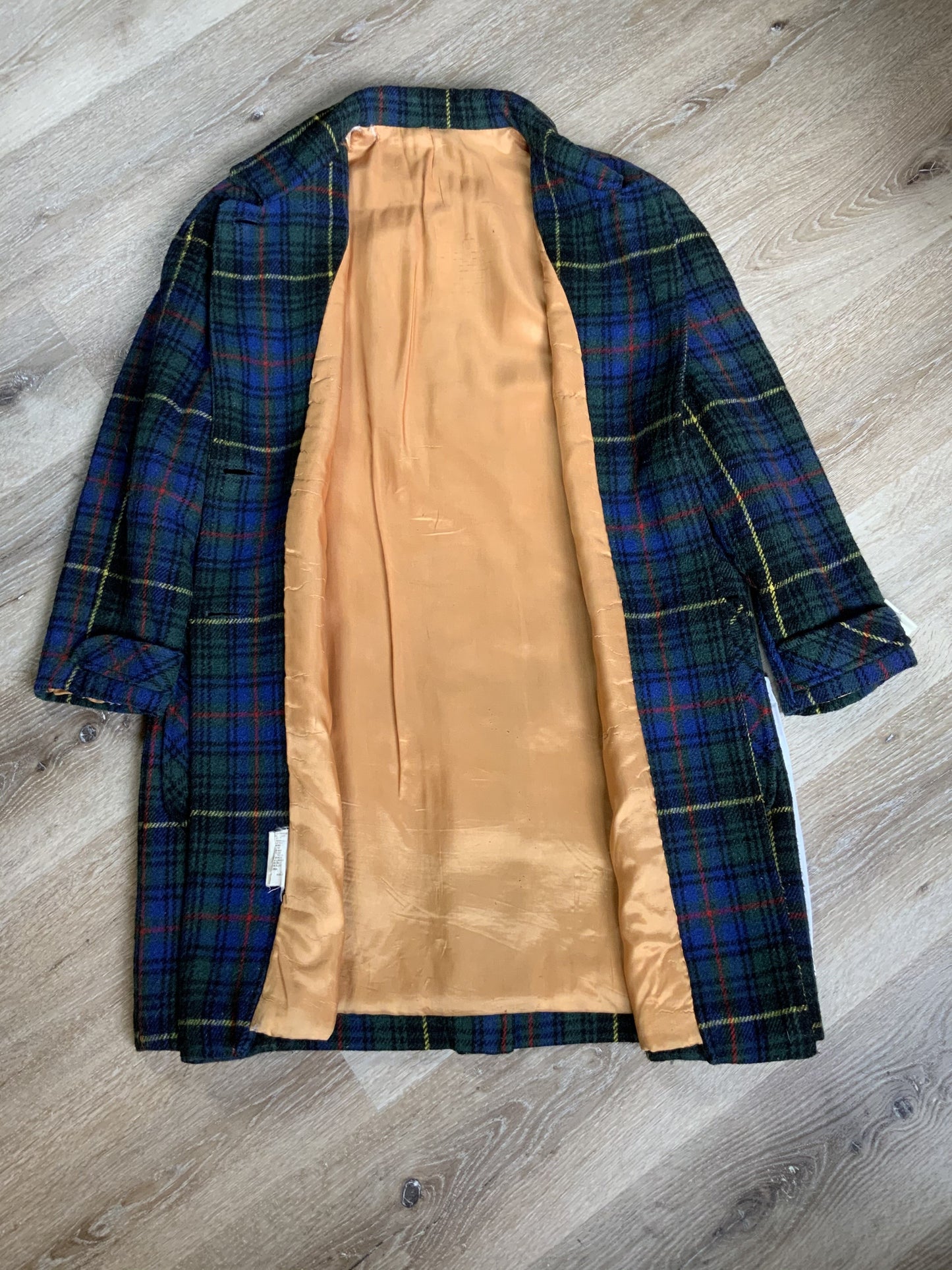Kingspier Vintage - This coat features a striking colour combination of royal blue, green, yellow, red and black plaid. It is a wool blend shell with button closures, front pockets and bright orange lining. It fits a size large.