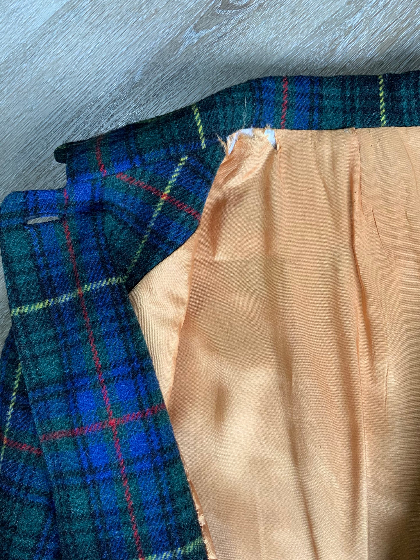 Kingspier Vintage - This coat features a striking colour combination of royal blue, green, yellow, red and black plaid. It is a wool blend shell with button closures, front pockets and bright orange lining. It fits a size large.