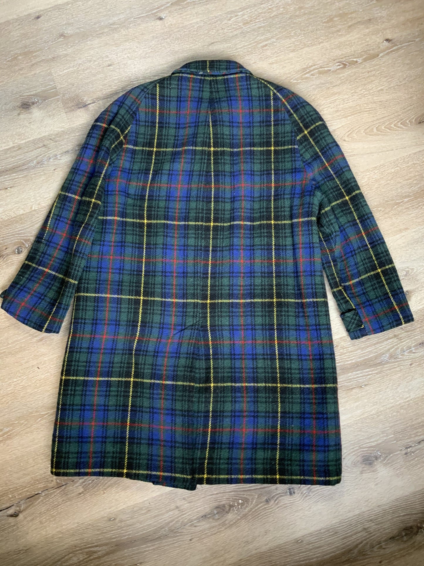 Kingspier Vintage - This coat features a striking colour combination of royal blue, green, yellow, red and black plaid. It is a wool blend shell with button closures, front pockets and bright orange lining. It fits a size large.