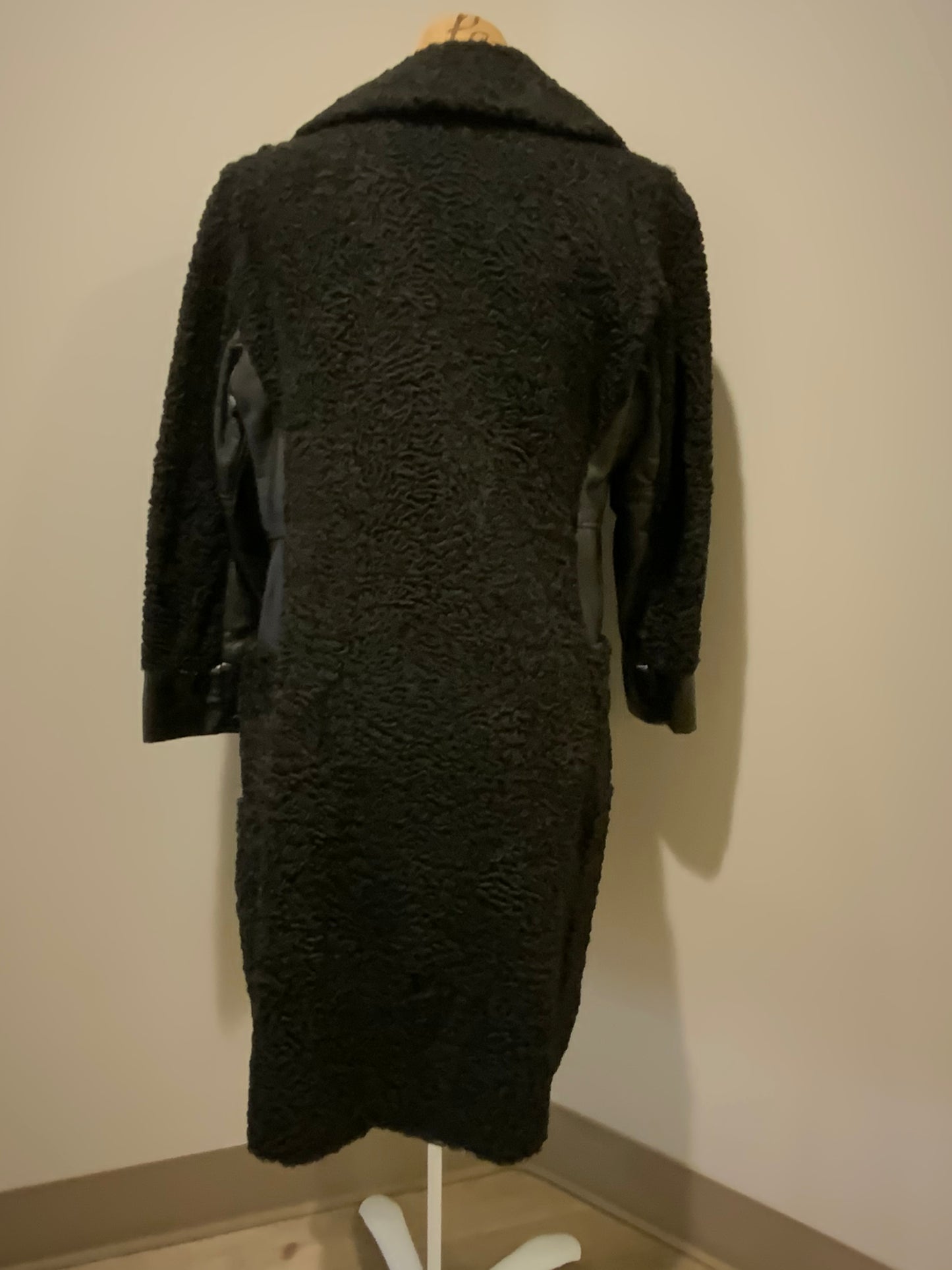 Kingspier Vintage - Salon Fernande Furs black persian wool coat with black leather trim details, four button closures down the front pockets and striking blue and bronze paisley lining with inside pockets. Made in Montreal.