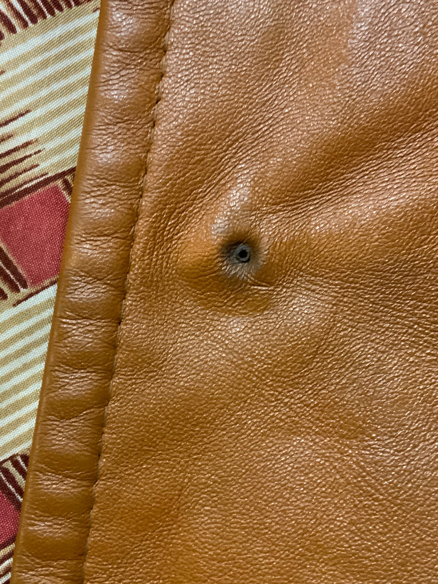 Kingspier Vintage - Form fitting 1970’s full length caramel brown leather coat with buttons down the front and a fun woven motif lining.