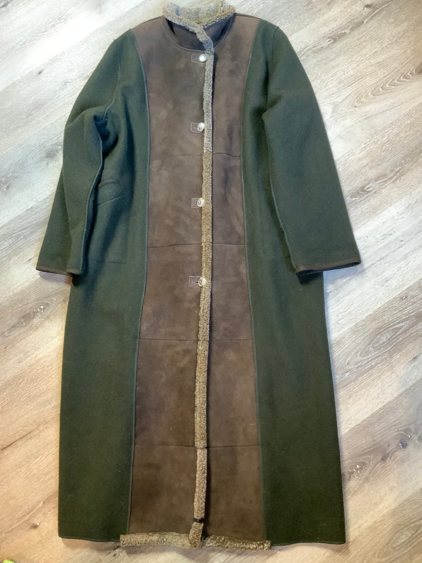 Kingspier Vintage - Epsilon full length moss green 100% wool coat with sheepskin panel running down the front. button closures with unique flower detail, front pockets and a zip out inside lining. Made in Canada. Fits a size large.