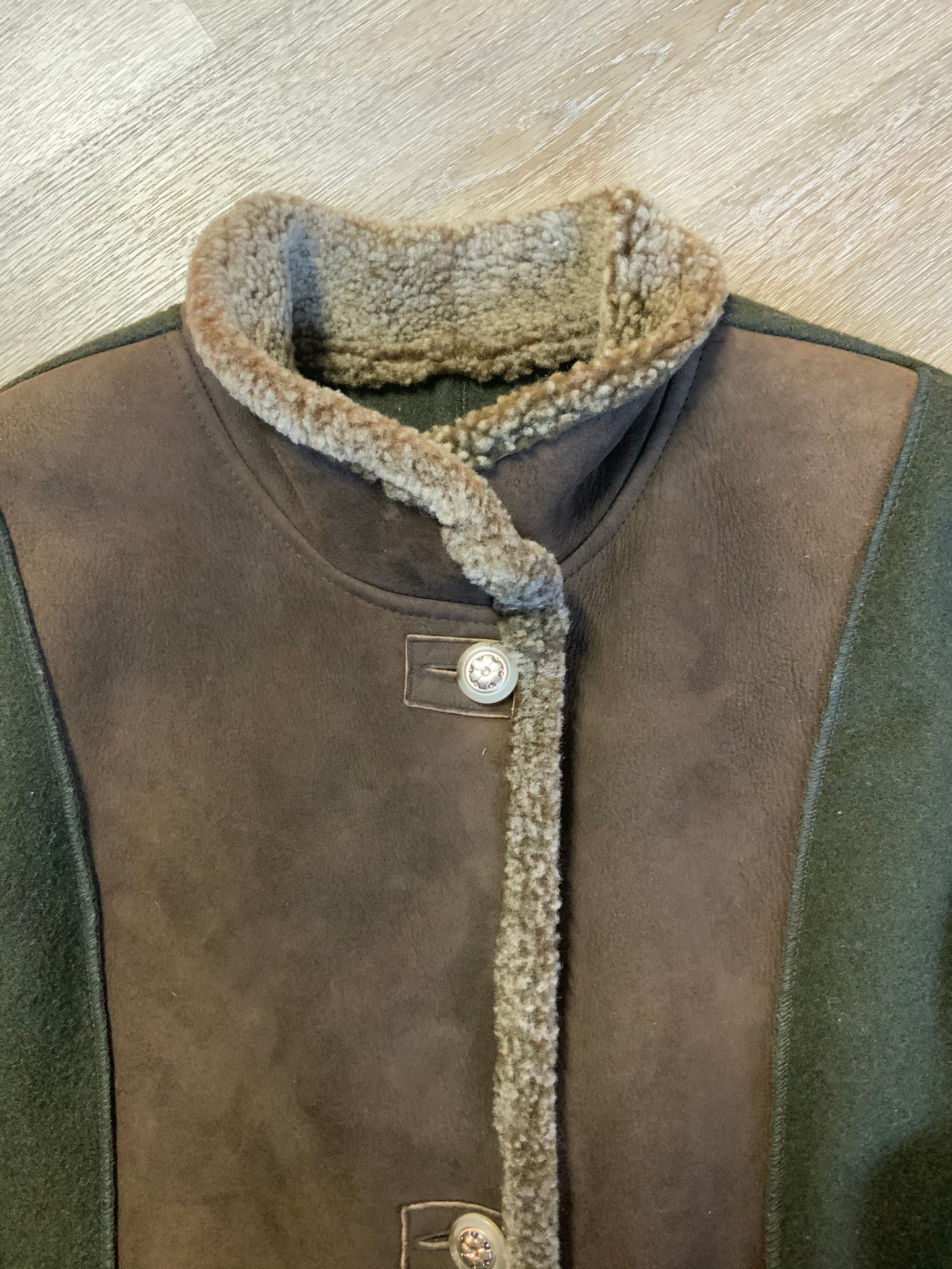 Kingspier Vintage - Epsilon full length moss green 100% wool coat with sheepskin panel running down the front. button closures with unique flower detail, front pockets and a zip out inside lining. Made in Canada. Fits a size large.