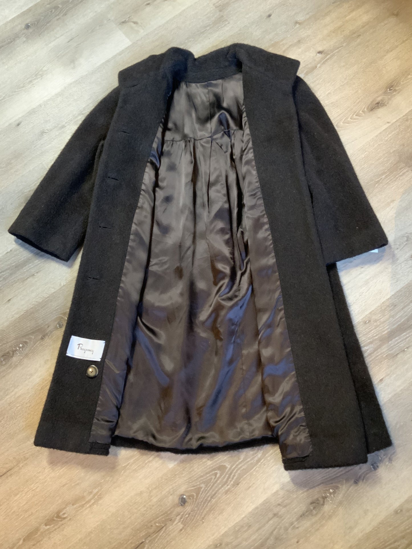 Kingspier Vintage - Regency 1970’s dark brown alpaca wool full length coat with front pockets and buttons, shoulder pads and pleating detail in the back. Features an ILGWU, Made in the USA label on inner lining. Fits a Size 8.