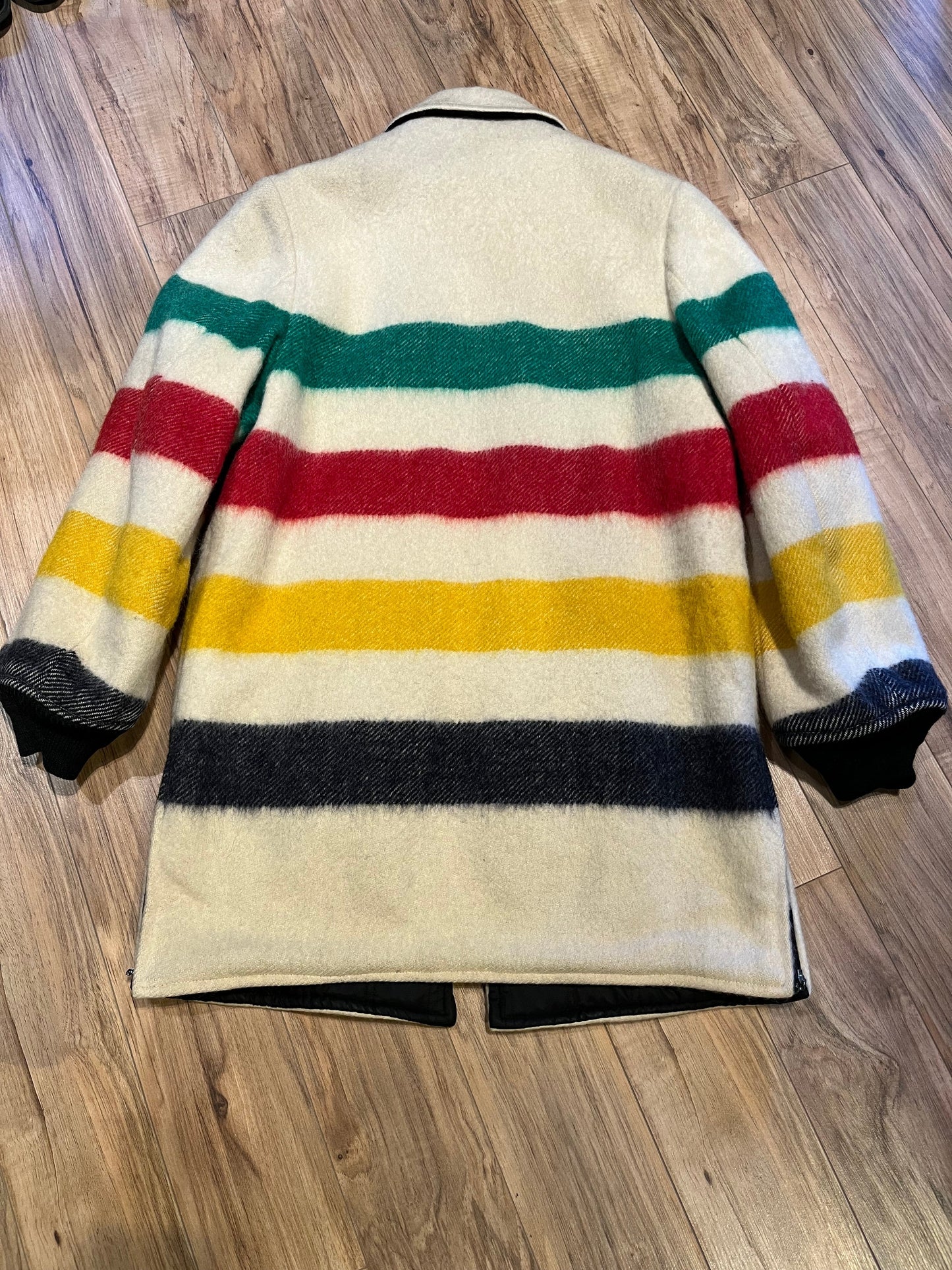 Genuine Hudson’s Bay Company 100% wool point blanket coat in the iconic multi-stripe colours. The coat features a reversible black nylon side with a hood zipped into the collar, zip pockets on both sides and knit cuffs.
Made in Canada.
Chest measures 42”.