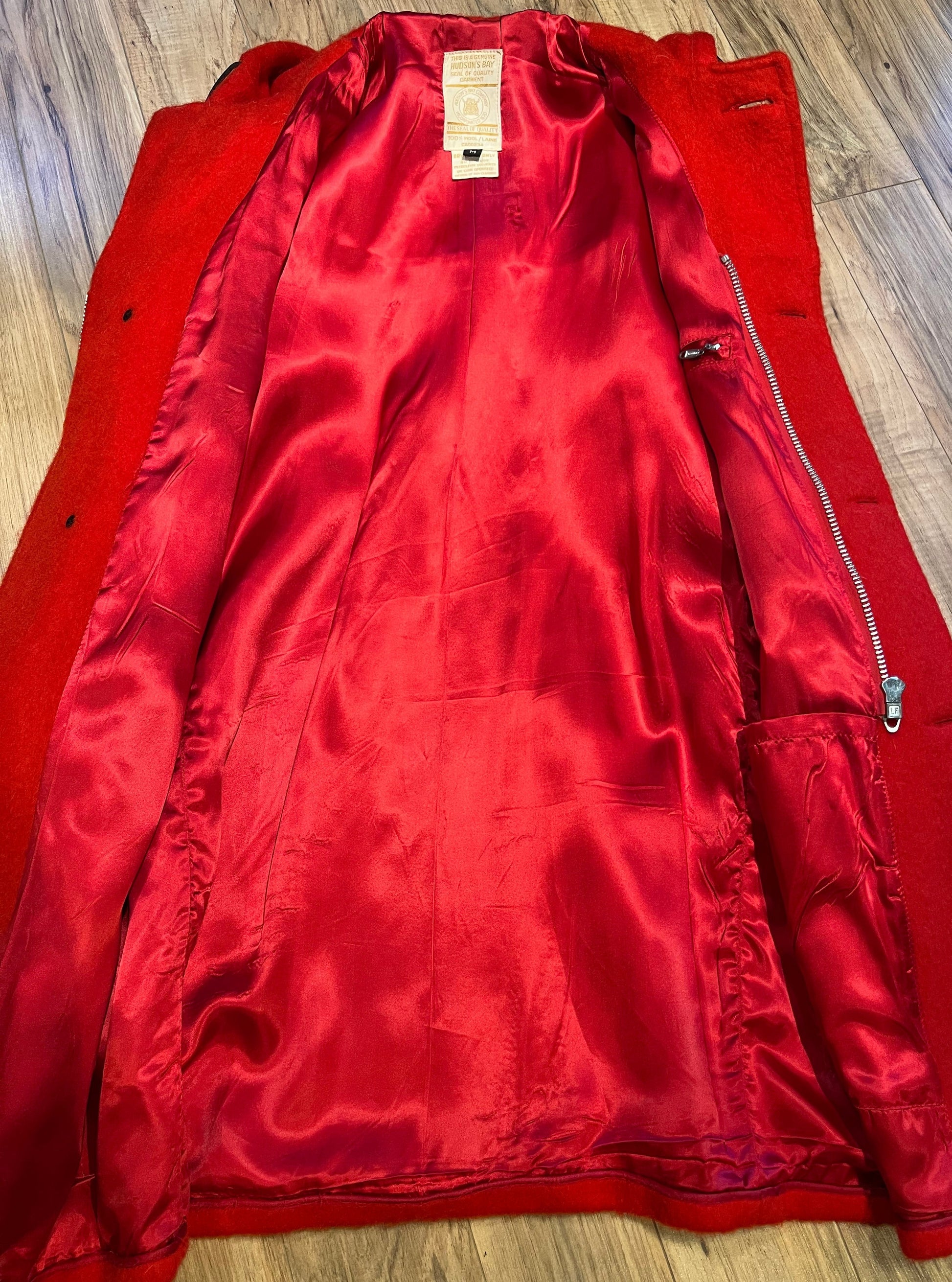 Genuine Hudson’s Bay Company 100% wool point blanket coat in bright red. The coat features flap pockets and hand warmer pockets, leather buttons, zip closure and a hood. 
Made in Canada. 
Size medium.