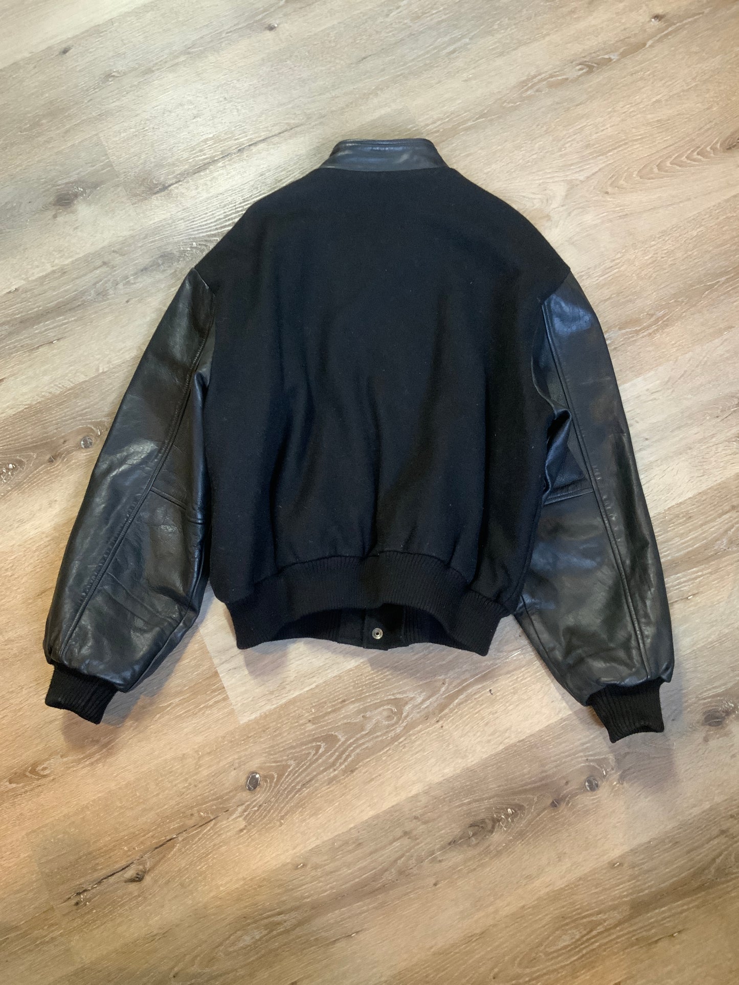 Kingspier Vintage - Dartmouth High School AAA Hockey letterman’s jacket in black with snap closures, slash pockets, quilted lining and embroidered team emblem. Made in Canada. Size XL.