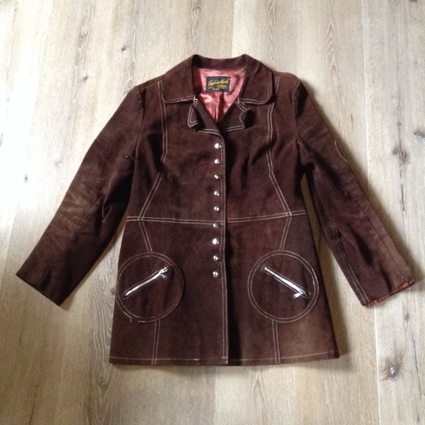 Kingspier Vintage - Vintage Sylvia Mark brown suede belted jacket with snap closures, decorative stitching, unique round pockets and pink satin lining. Made in Canada. Size Medium.