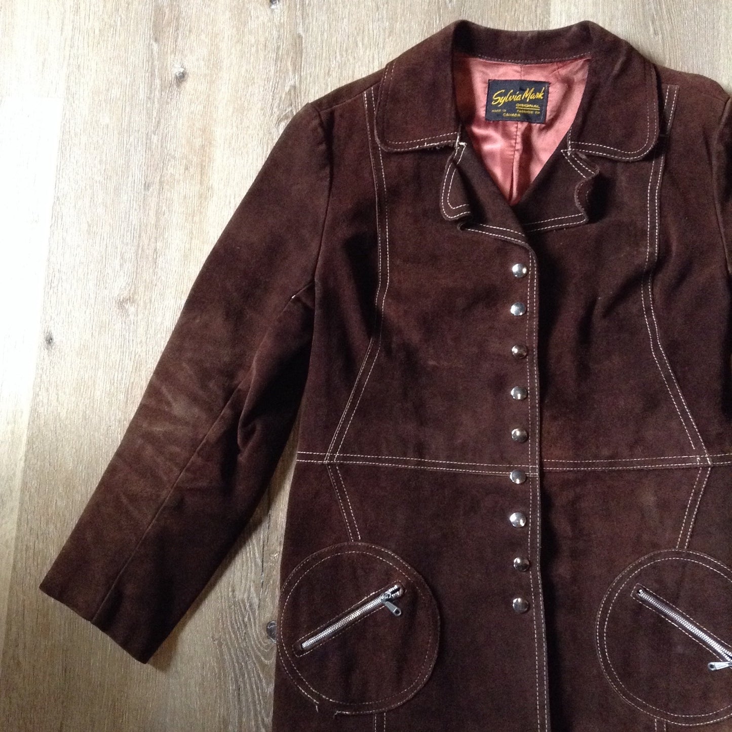 Kingspier Vintage - Vintage Sylvia Mark brown suede belted jacket with snap closures, decorative stitching, unique round pockets and pink satin lining. Made in Canada. Size Medium.