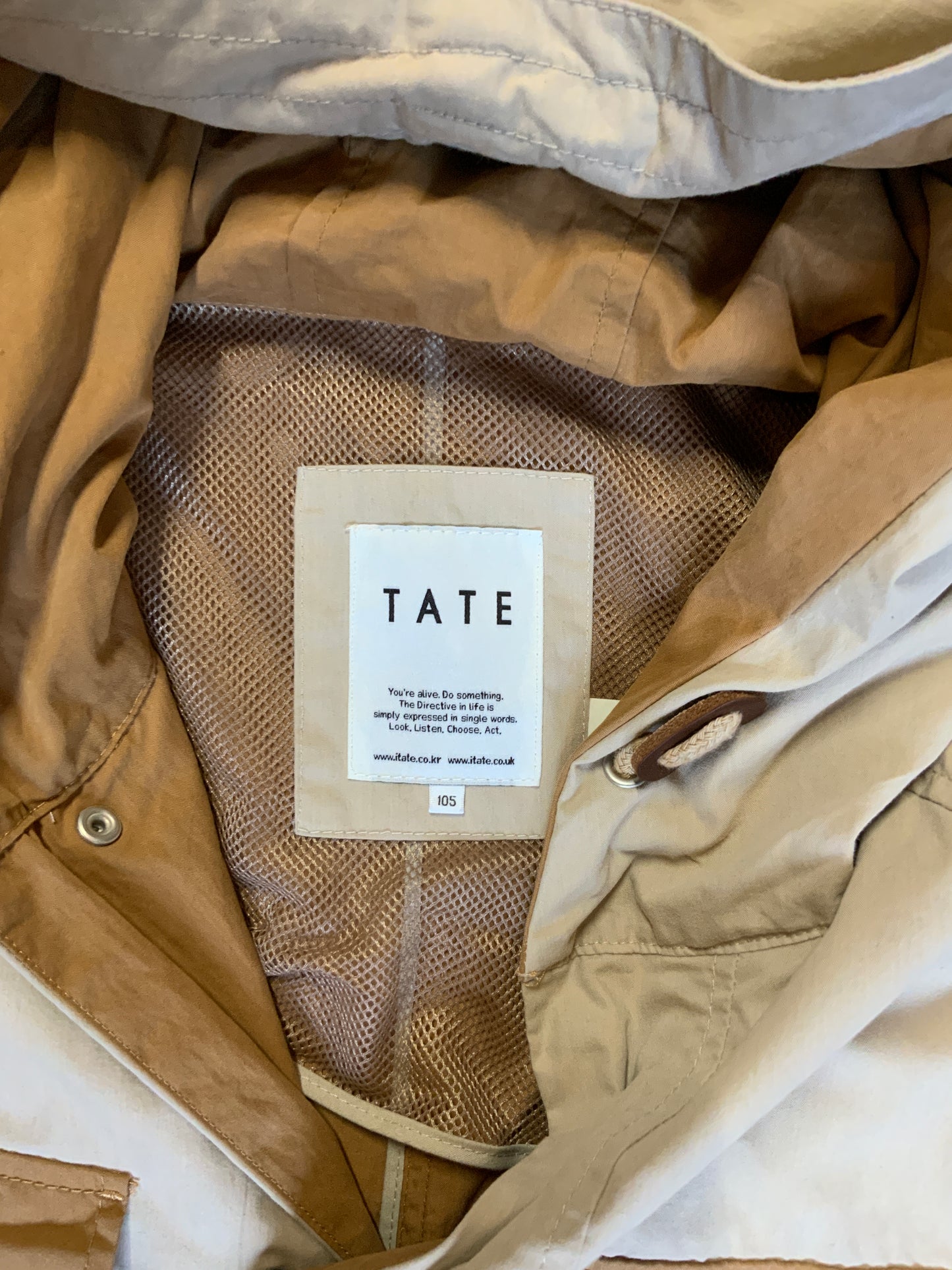 Kingspier Vintage - Tate beige and tan field jacket with hood, button closures, flap pockets, vent in the back, elbow patches and drawstring at the waist and the bottom hem.