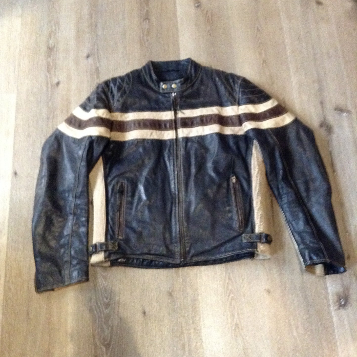 Kingspier Vintage -Vintage CCM Canada black, white and brown leather moto jacket with zipper closure, pockets and a snap collar. Size XL.