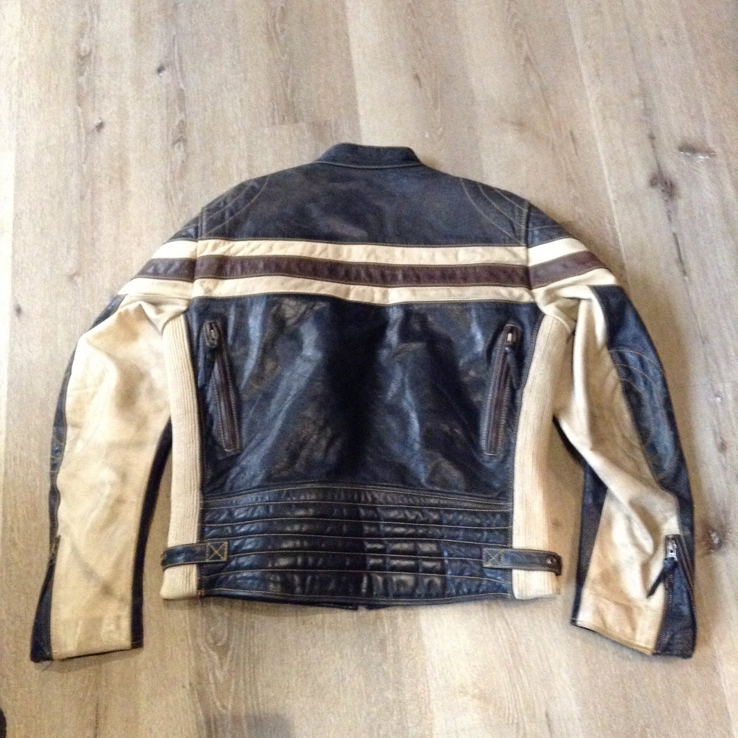 Kingspier Vintage -Vintage CCM Canada black, white and brown leather moto jacket with zipper closure, pockets and a snap collar. Size XL.