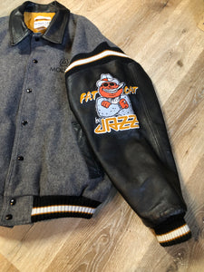Kingspier Vintage - Fat Cat by Jazz grey and black wool varsity jacket with two large custom Jazz Golf embroidered patches on the arm and the back and Molson is embroidered on the chest in black, leather sleeves and collar, pockets, snap closures, knit details and a quilted lining. Made in Canada by Mondetta . Size XL.