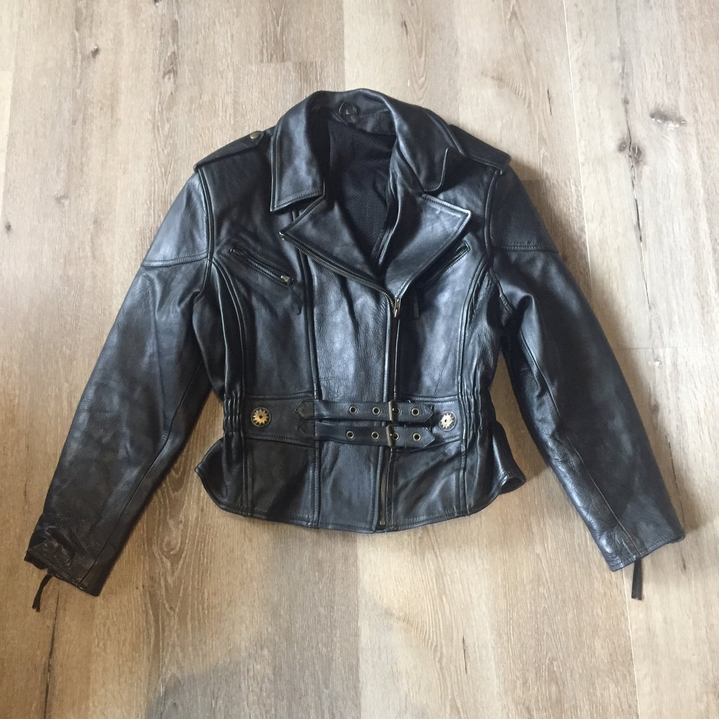 Kingspier Vintage -Vintage black leather moto jacket with brass hardware and zipper closure, belt details and a zipper reveals a vent in the back . Size large.