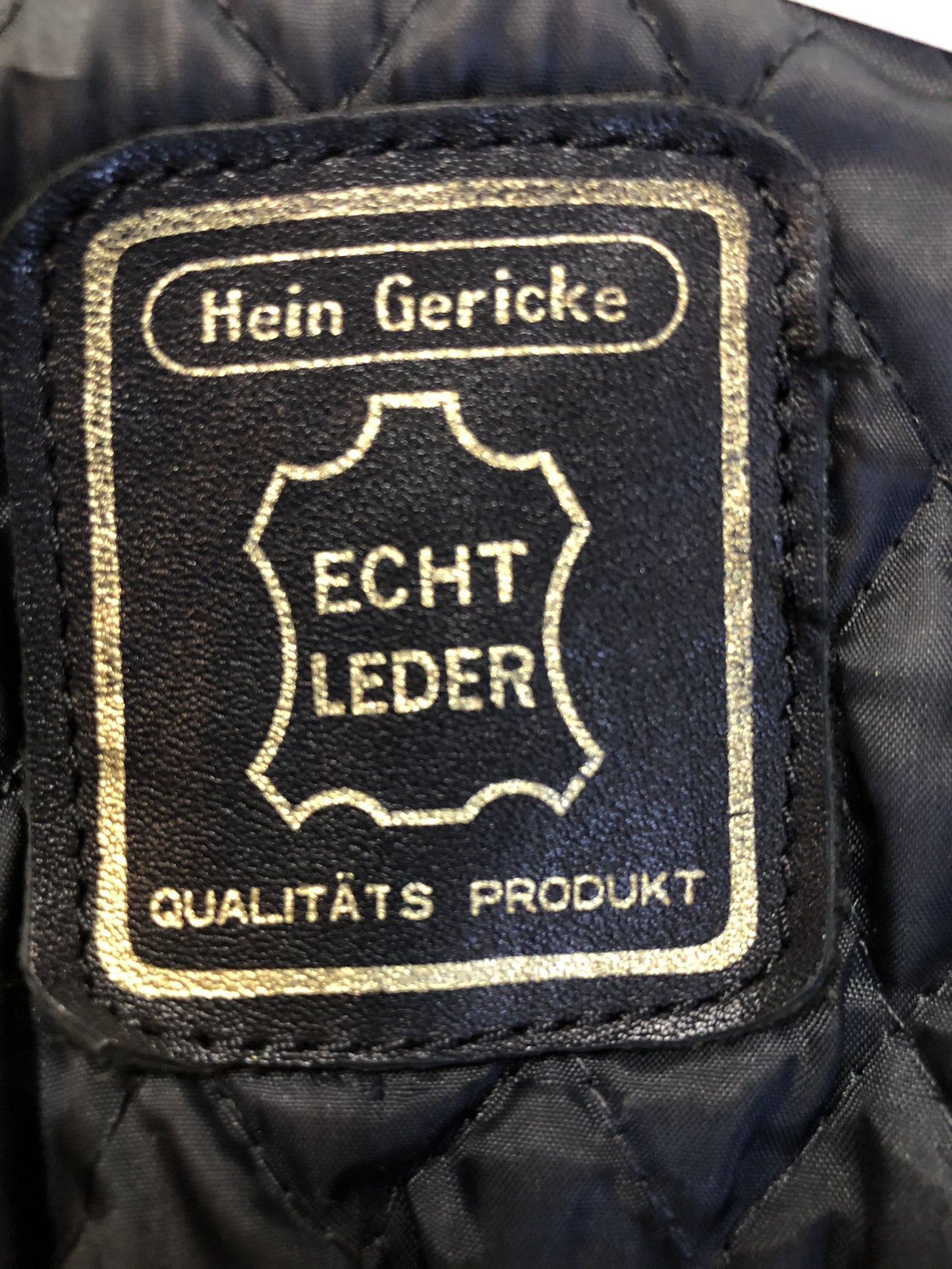 Kingspier Vintage - Hein Gericks black leather motorcycle jacket with fringe detail, zipper, vertical zip pockets lace-up shoulder detail, a quilted lining with inside pocket. Fits Small.