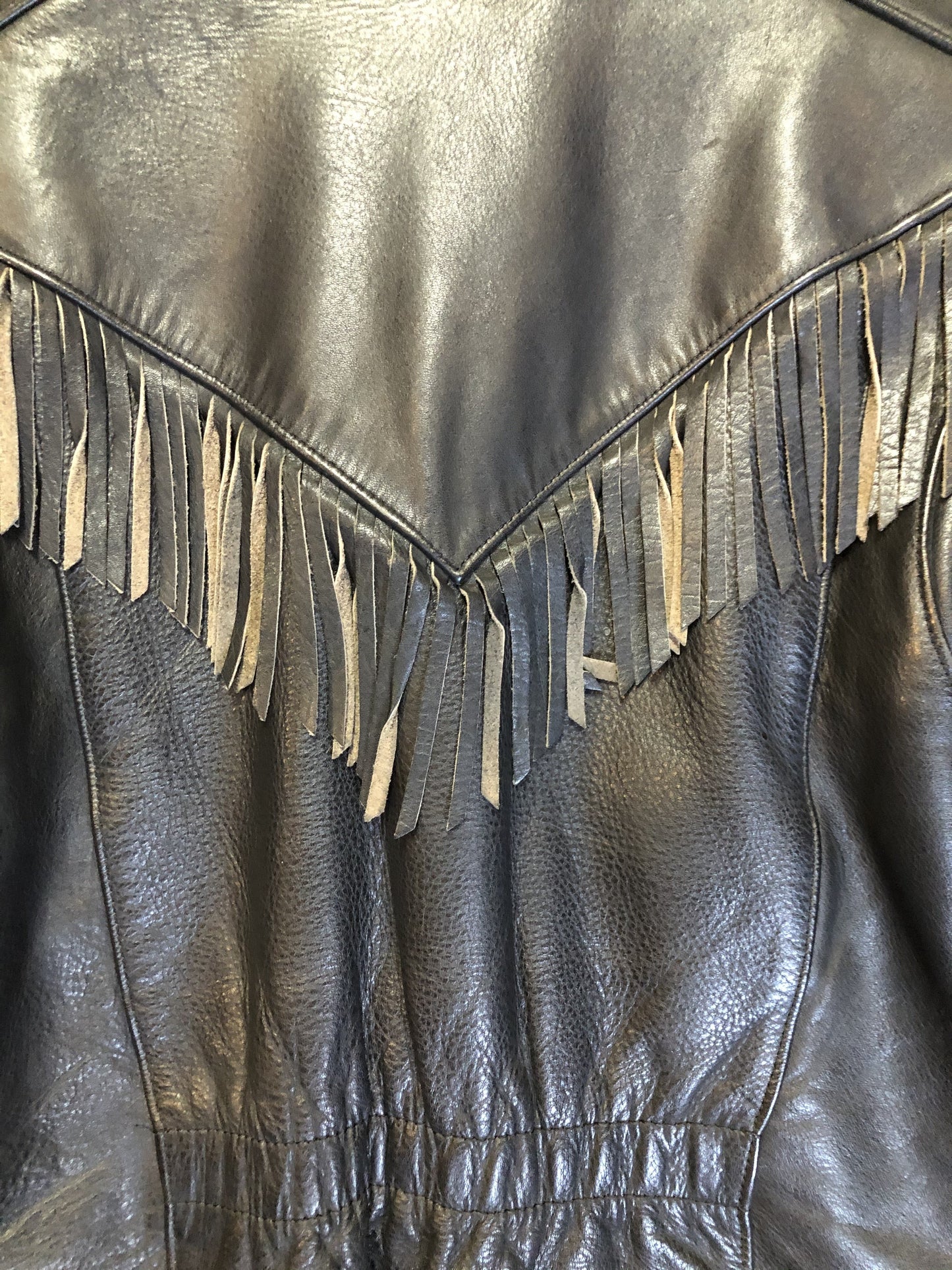 Kingspier Vintage - Hein Gericks black leather motorcycle jacket with fringe detail, zipper, vertical zip pockets lace-up shoulder detail, a quilted lining with inside pocket. Fits Small.