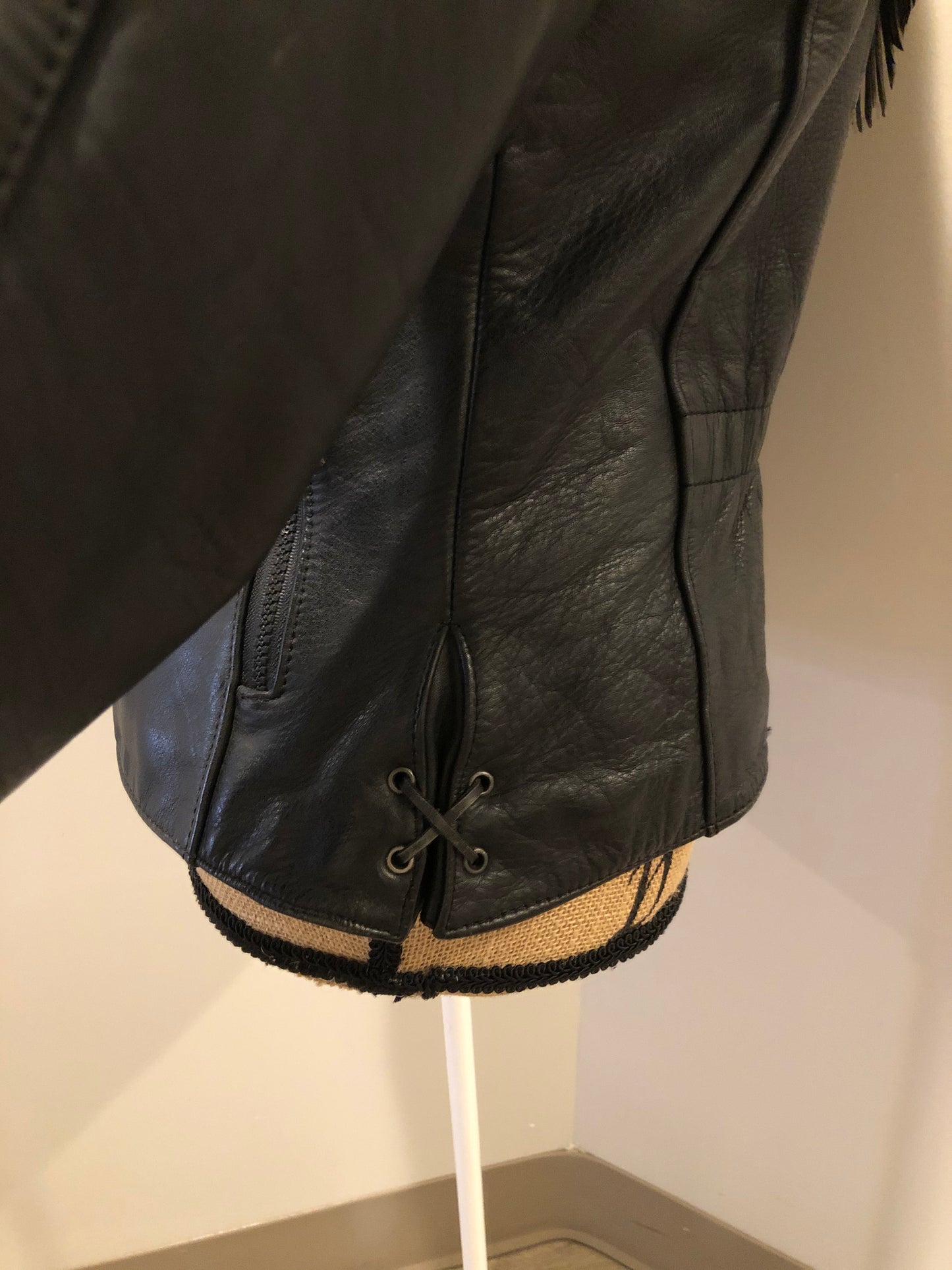 Kingspier Vintage - Hein Gericks black leather motorcycle jacket with fringe detail, zipper, vertical zip pockets lace-up shoulder detail, a quilted lining with inside pocket. Fits Small.