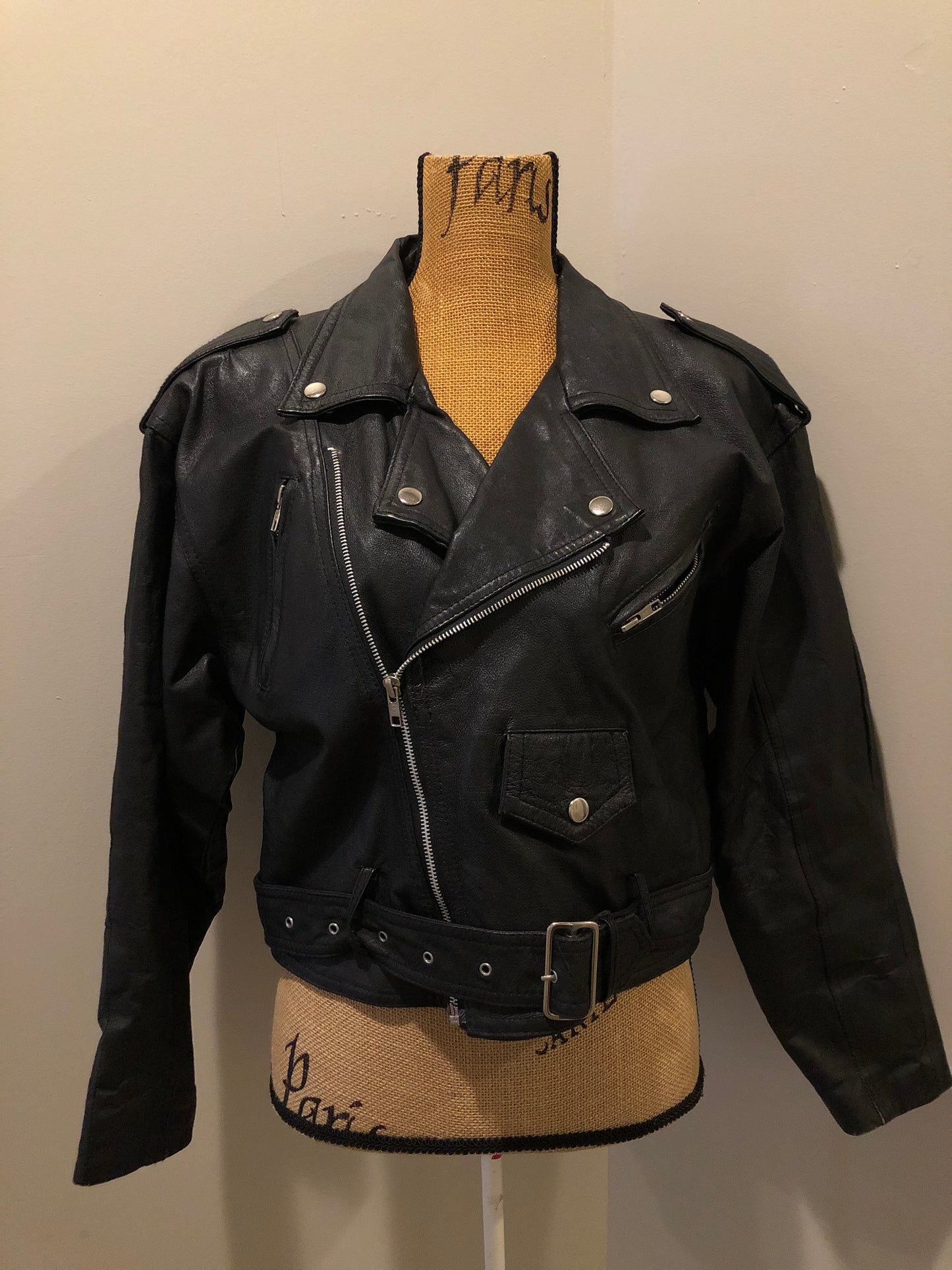 Kingspier Vintage - Cosa Nova black leather motorcycle jacket with two slash pockets, one flap pocket and a belt at the waist. Made in Canada. Size large.
