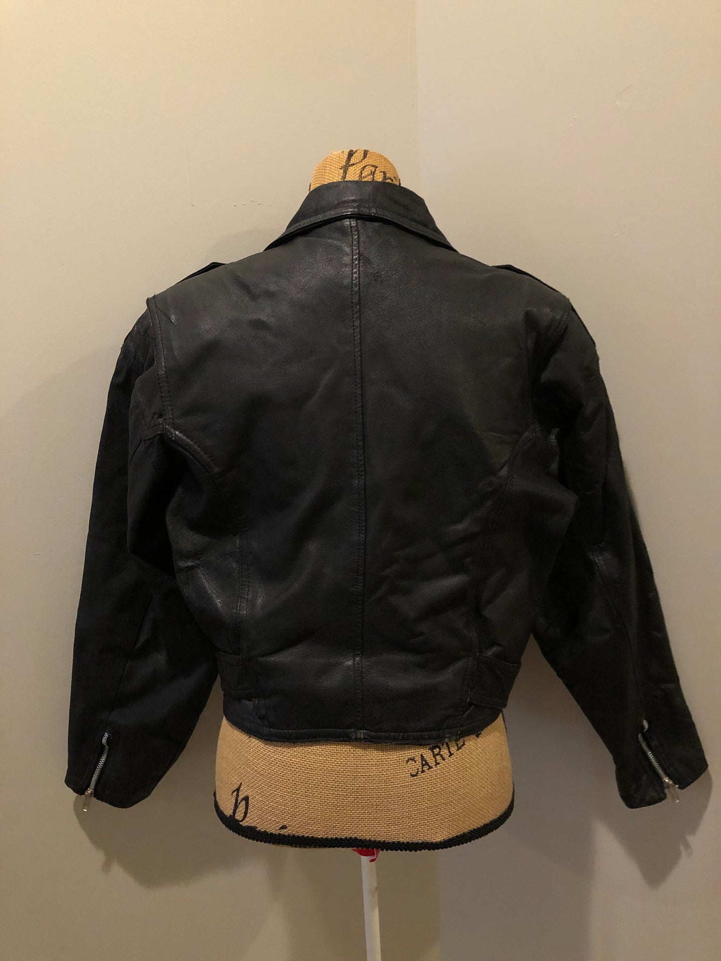 Kingspier Vintage - Cosa Nova black leather motorcycle jacket with two slash pockets, one flap pocket and a belt at the waist. Made in Canada. Size large.
