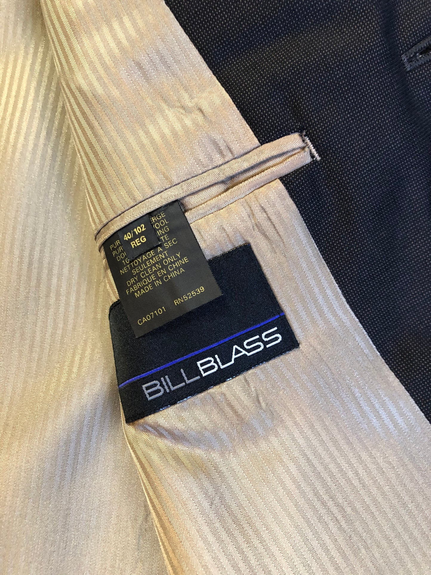 Kingspier Vintage - Bill Blass dark brown 100% pure wool two piece suit. The jacket is a single breasted three button notch lapel with two flap pockets and a beige lining with two inside pockets, Pants are pleated with welt pockets.