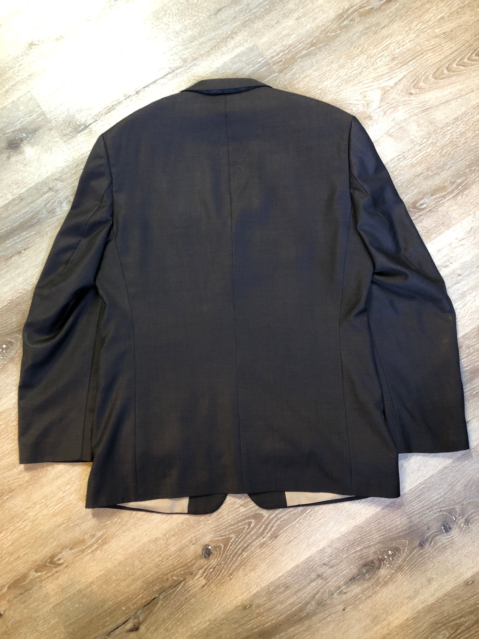 Kingspier Vintage - Bill Blass dark brown 100% pure wool two piece suit. The jacket is a single breasted three button notch lapel with two flap pockets and a beige lining with two inside pockets, Pants are pleated with welt pockets.