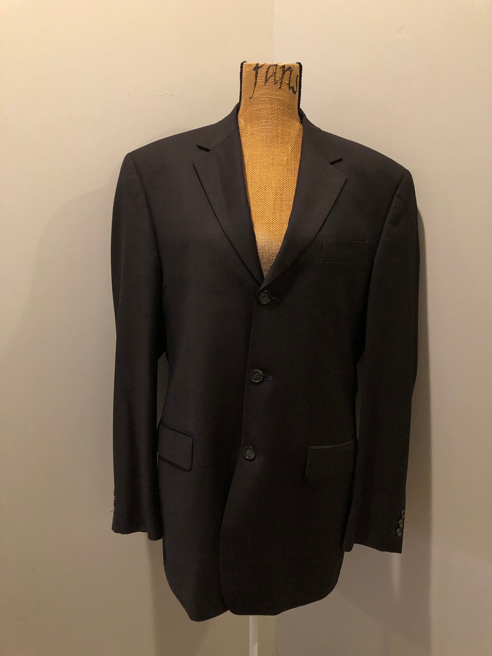 Kingspier Vintage - Bill Blass dark brown 100% pure wool two piece suit. The jacket is a single breasted three button notch lapel with two flap pockets and a beige lining with two inside pockets, Pants are pleated with welt pockets.