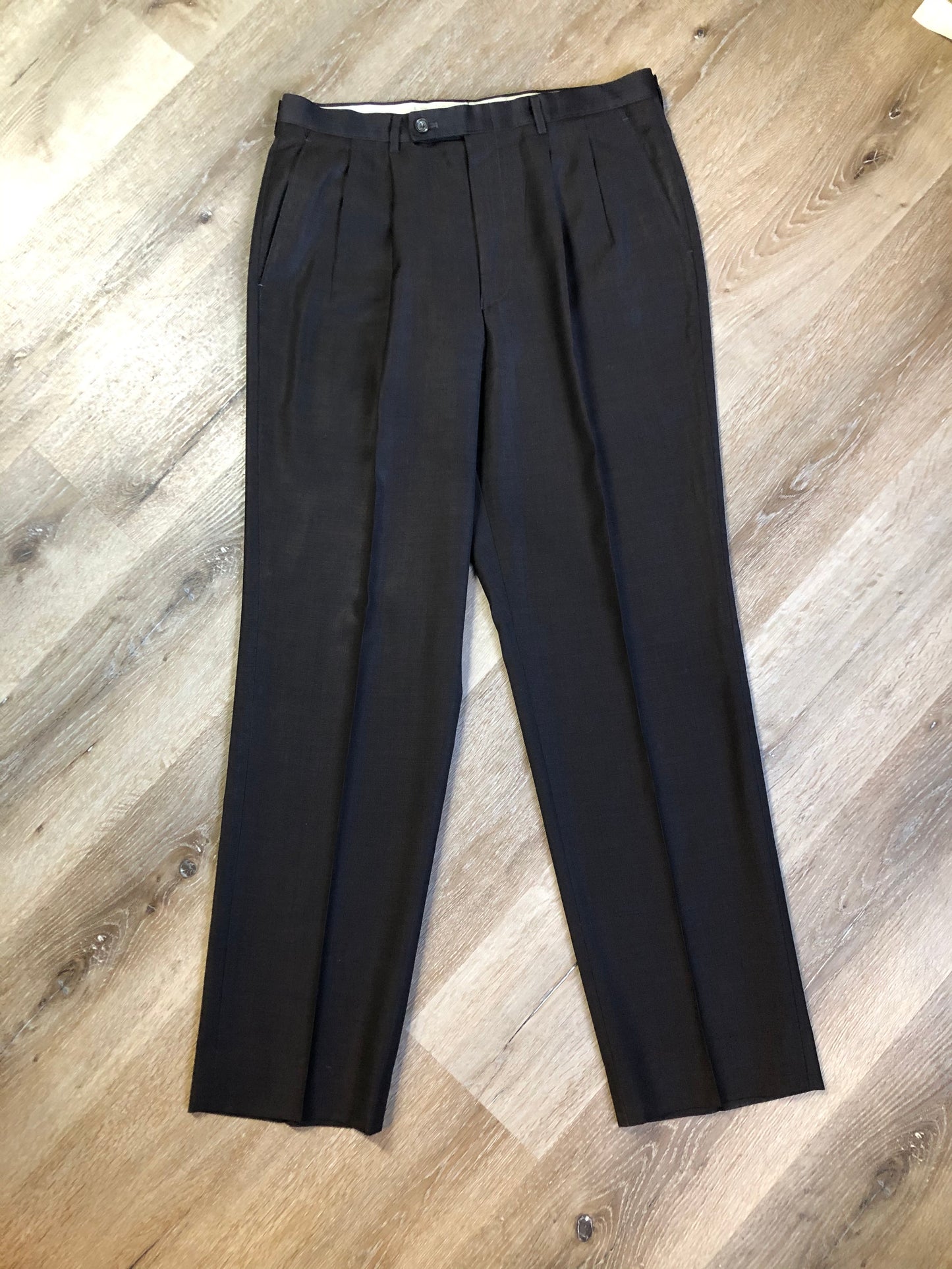 Kingspier Vintage - Bill Blass dark brown 100% pure wool two piece suit. The jacket is a single breasted three button notch lapel with two flap pockets and a beige lining with two inside pockets, Pants are pleated with welt pockets.