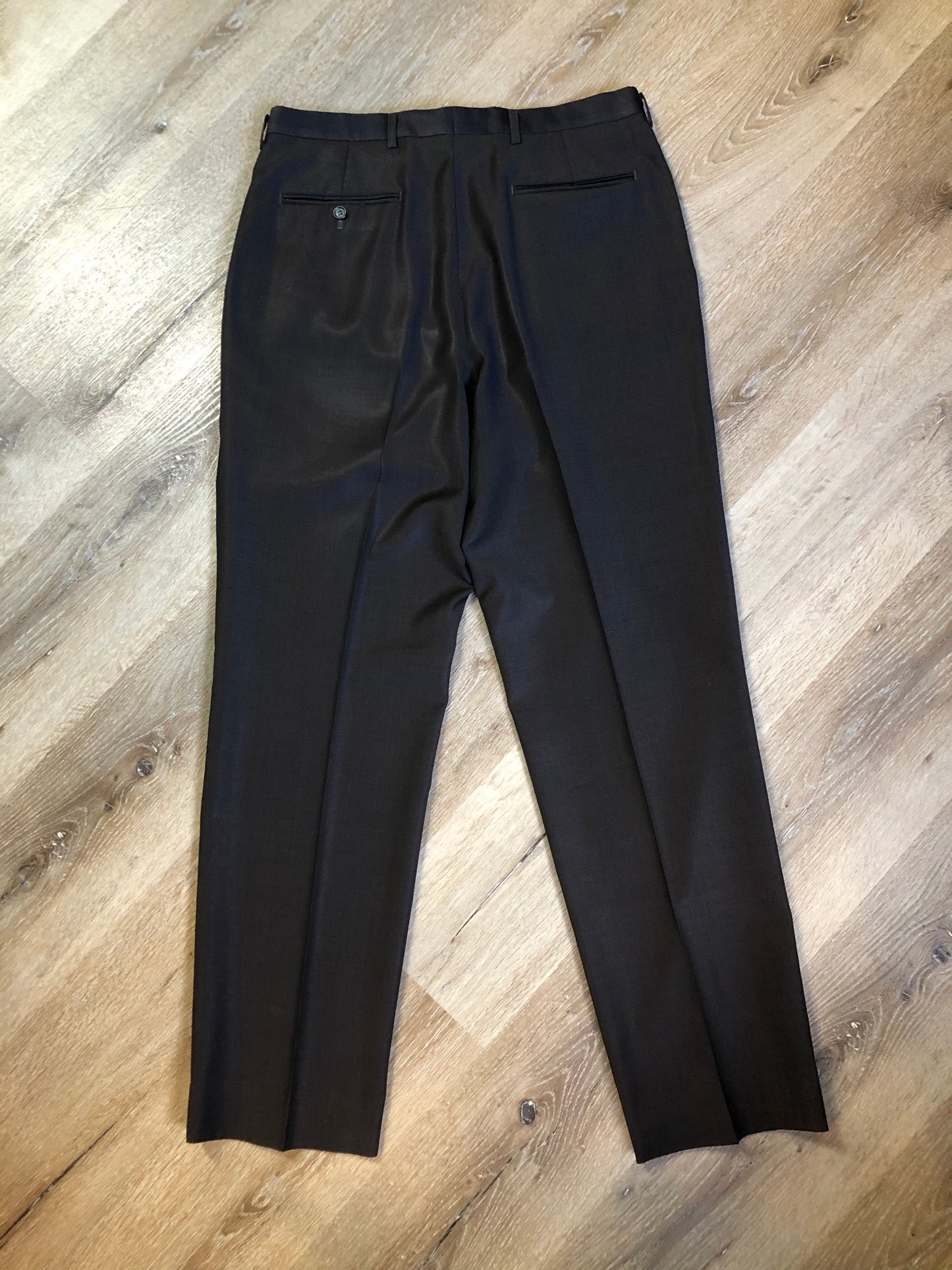 Kingspier Vintage - Bill Blass dark brown 100% pure wool two piece suit. The jacket is a single breasted three button notch lapel with two flap pockets and a beige lining with two inside pockets, Pants are pleated with welt pockets.