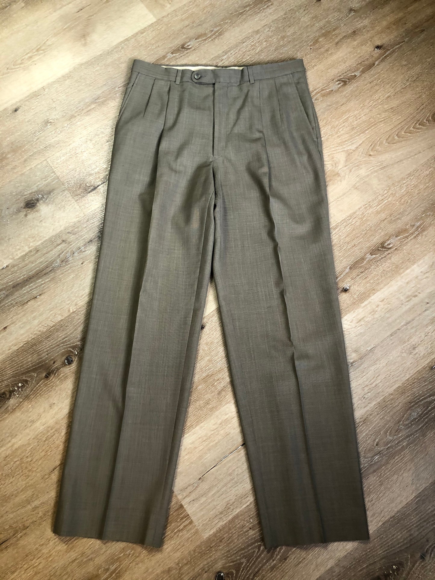 Kingspier Vintage - WM.H. Leishman (sold at Tip Top Tailors) two piece medium grey 100% pure virgin wool suit.The jacket is a single breasted, two button notch lapel with two flap pockets and two inside pockets. Pants are pleated with welt pockets. Made in Canada.