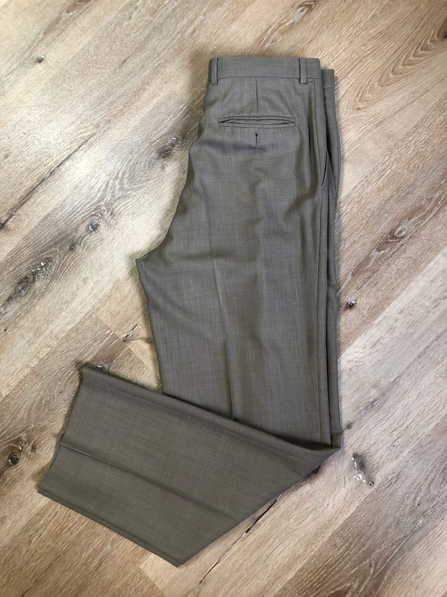 Kingspier Vintage - WM.H. Leishman (sold at Tip Top Tailors) two piece medium grey 100% pure virgin wool suit.The jacket is a single breasted, two button notch lapel with two flap pockets and two inside pockets. Pants are pleated with welt pockets. Made in Canada.