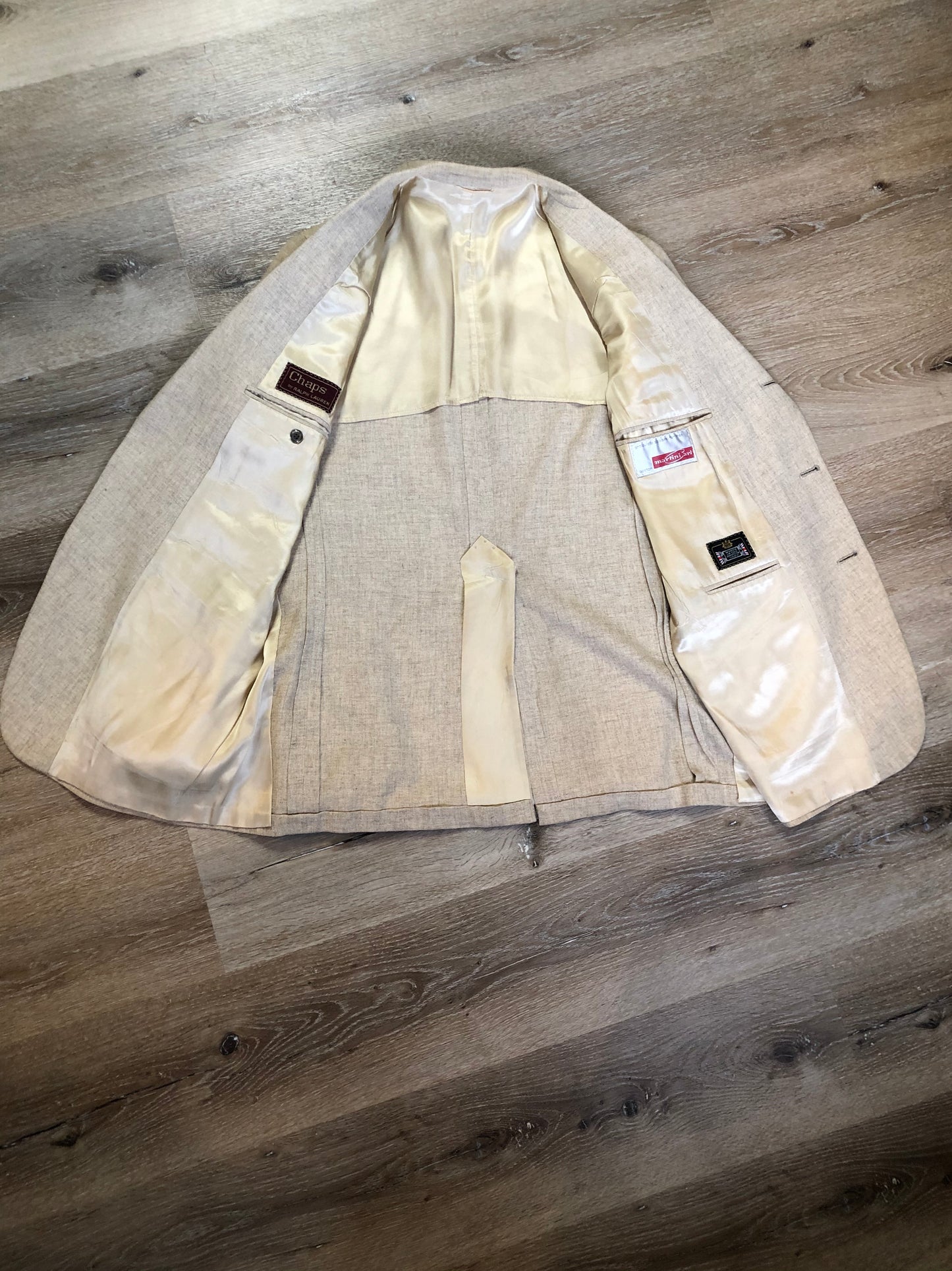 Kingspier Vintage - Chaps by Ralph Lauren light beige two piece suit at Martini Carl Boston. Jacket is a three button notch lapel with three flap pockets and a breast pocket. The pants are flat front with two slash pockets, a tiny flap pocket in the front and two back pockets.