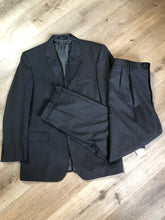 Load image into Gallery viewer, Kingspier Vintage - JoS. A. Bank, Signature Collection dark grey 100% wool two piece suit. Made in Mexico. Jacket is a three button notch lapel with two flap pockets and a breast pocket, three inside pockets and one coin pocket. Pants are pleated and cuffed with welt pockets in front and back and suspender buttons.
