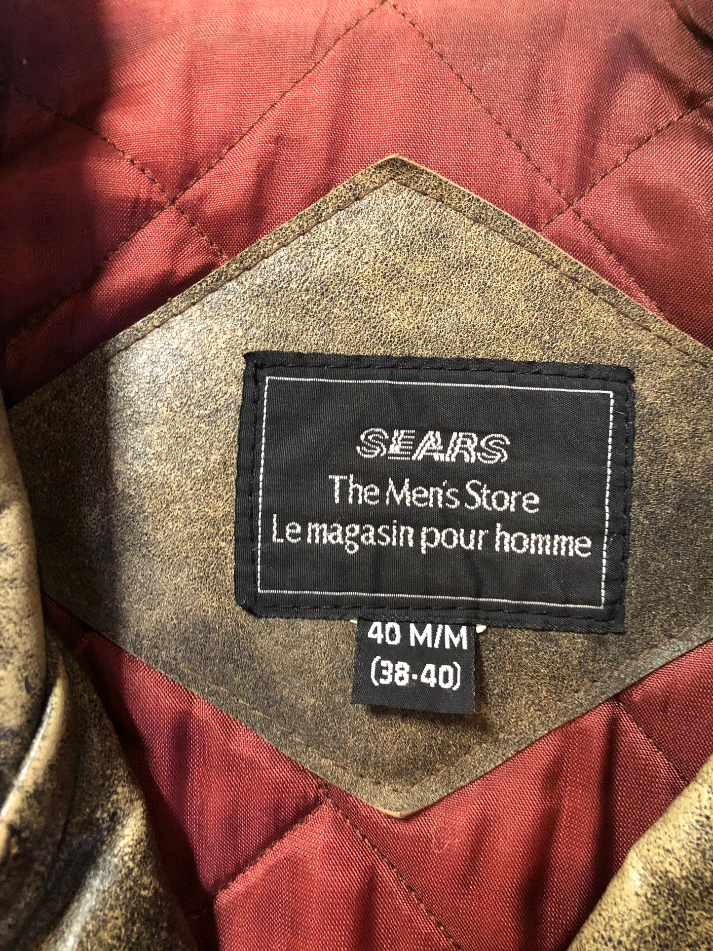Kingspier Vintage - Sears distressed brown leather motorcycle jacket with zipper, two vertical zip pockets, one flap pocket and a slash pocket on the chest, a belt at the waist and red quilted lining. Size medium.