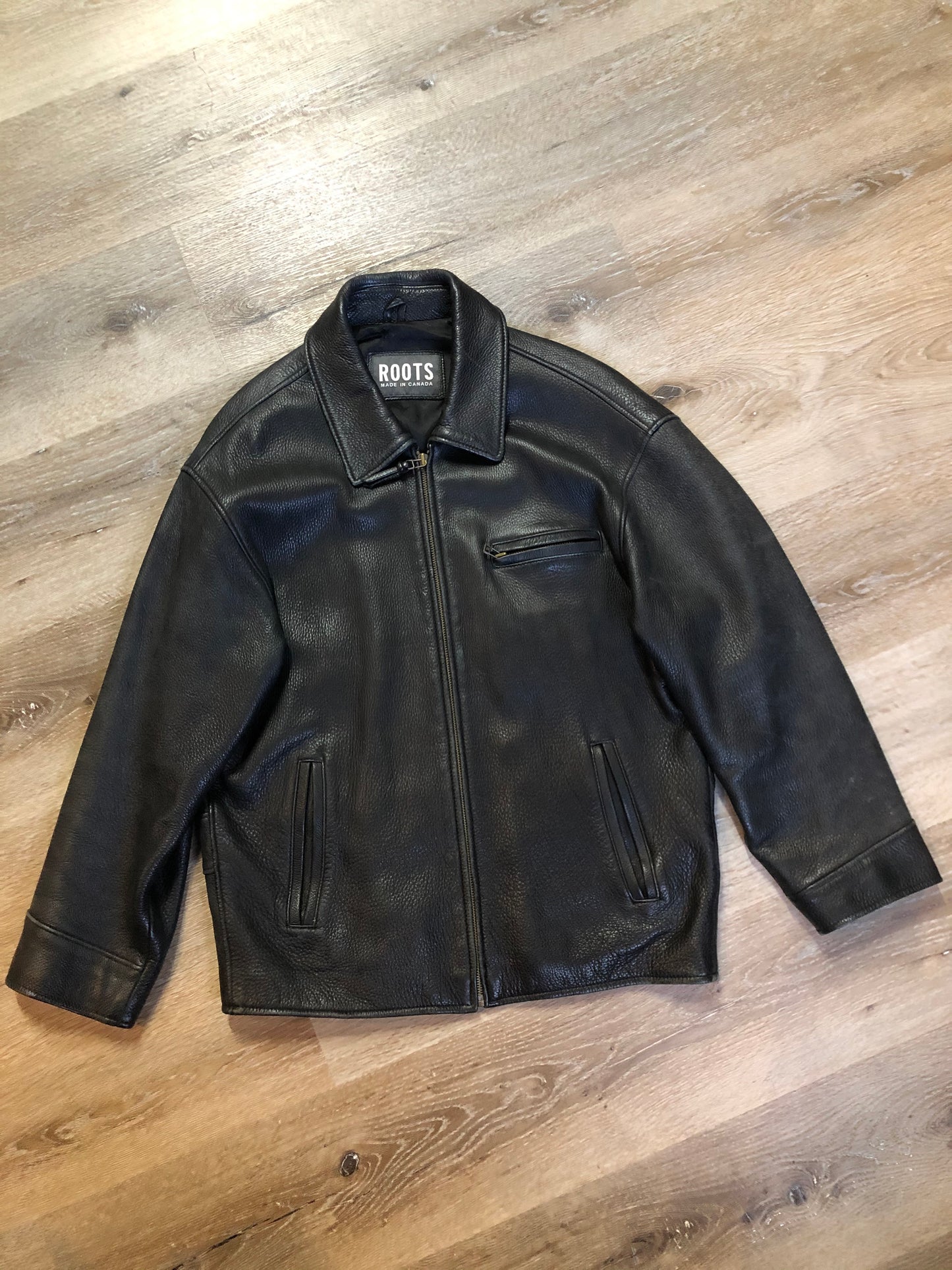 Kingspier Vintage - Roots black pebbled leather jacket with two vertical zip pockets and one zip pocket on the chest. Made in Canada. Size medium.