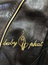 Load image into Gallery viewer, Kingspier Vintage - Baby Phat black leather moto jacket with gold piping and “Baby Phat” embroidered on the chest, front zipper and two vertical zip pockets. A pattern is stitched into the elbows and “Baby Phat” is stitched across the back. Size small.
