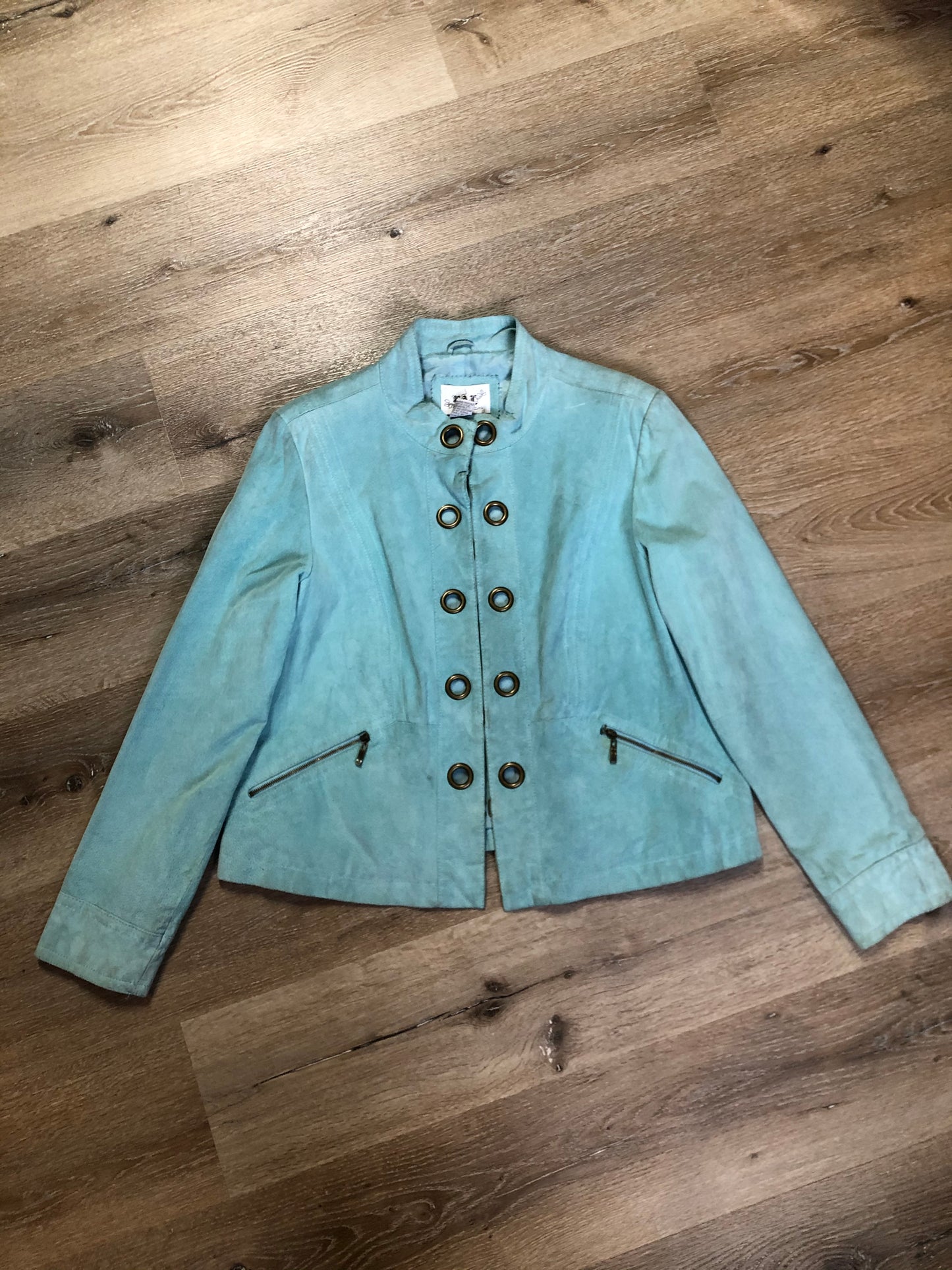 Kingspier Vintage - LAL “Live A LIttle” light teal suede jacket with hidden hook closures, brass grommets running down the front, two zip slash pockets and a small belt at the back. Size large.