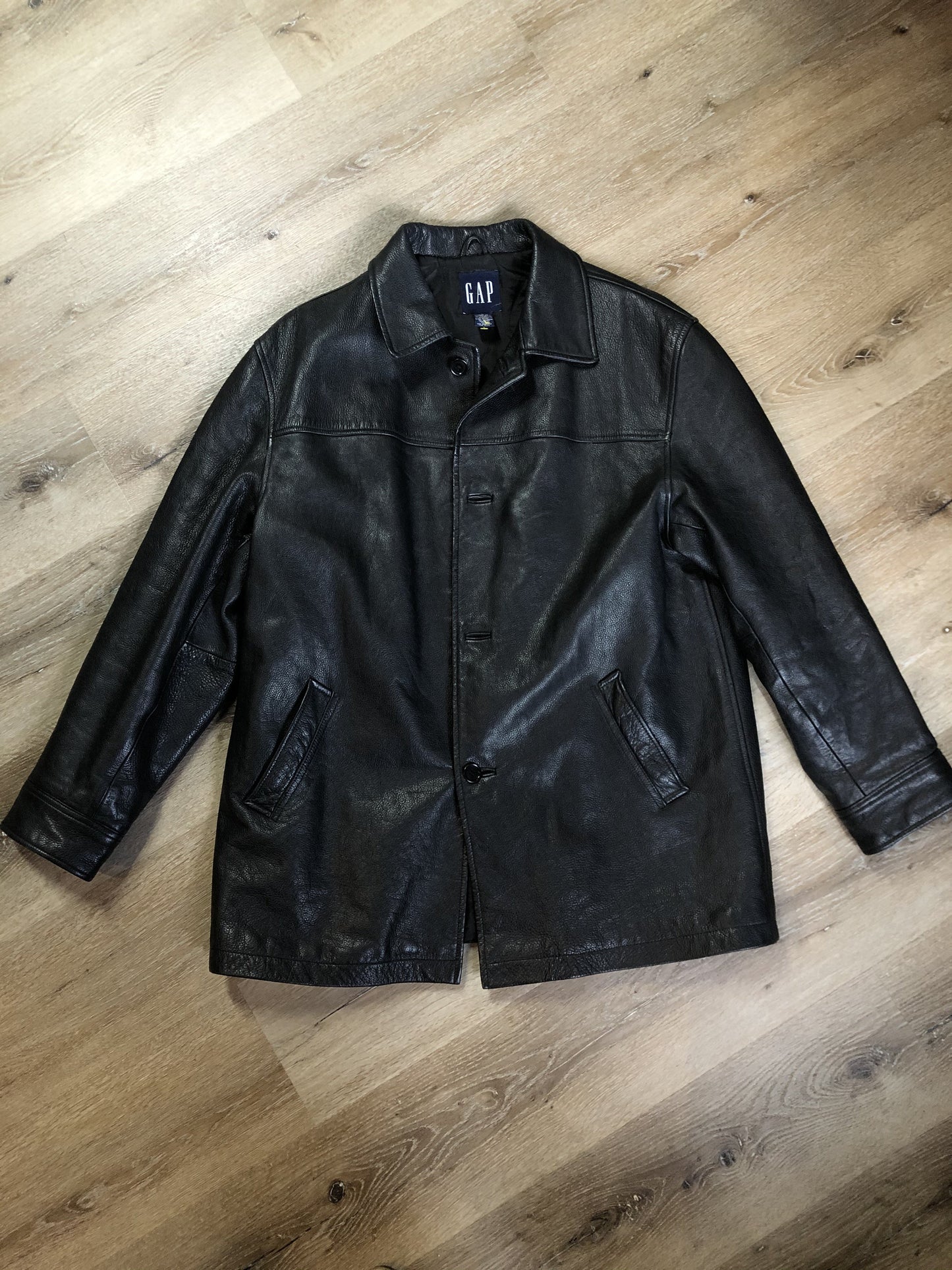 Kingspier Vintage - Gap black leather jacket with button closures, slash pockets, inside pocket and quilted lining. Size large.