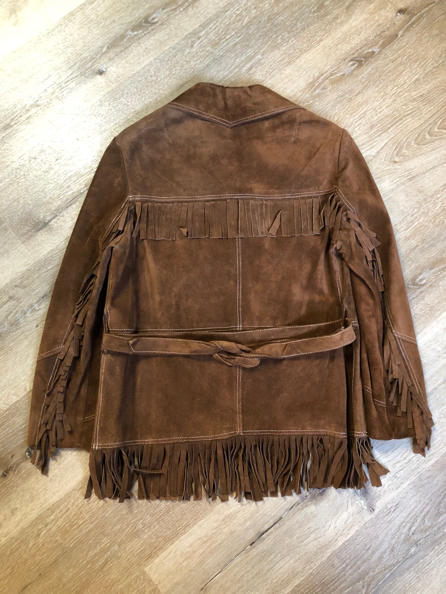Kingspier Vintage - Jonathan Legault brown suede western style jacket with fringe details, belt in the back, button closures and slash pockets.